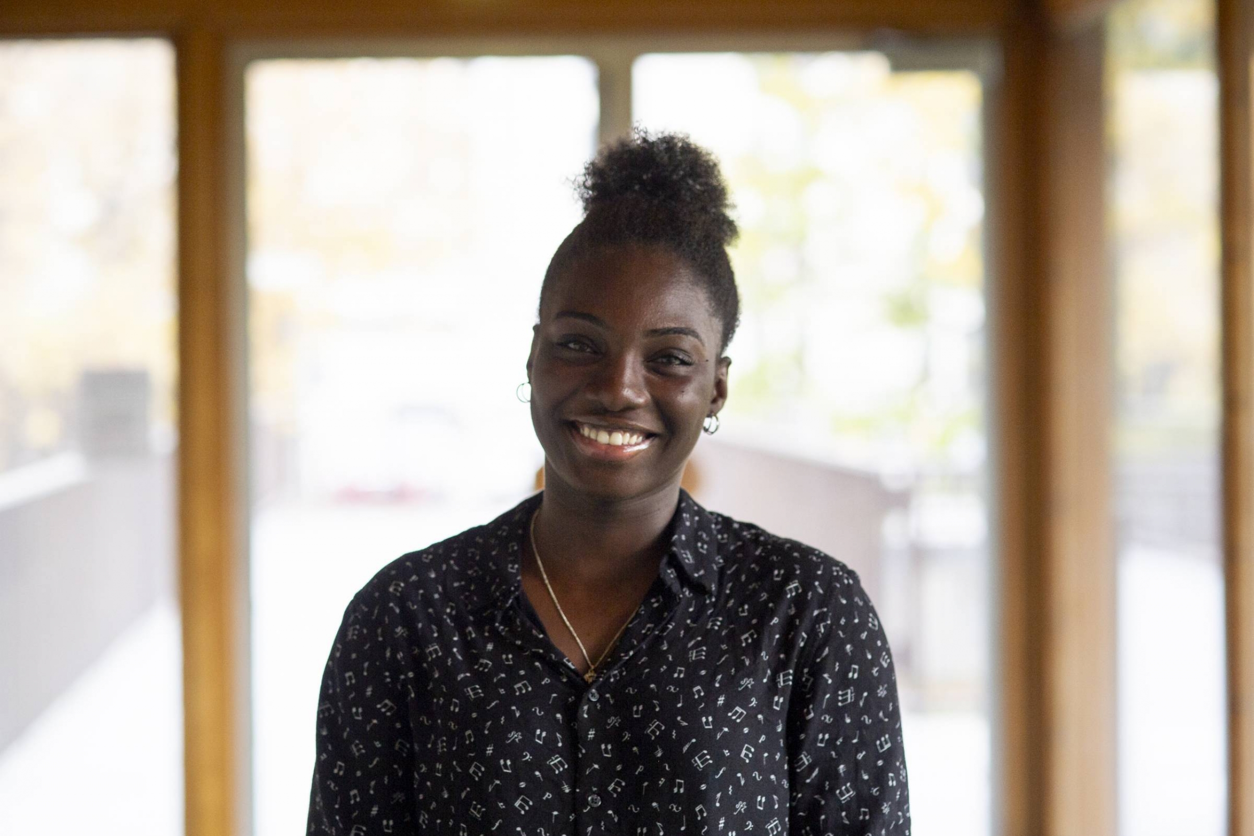 Eniola standing in front of a bright lit window