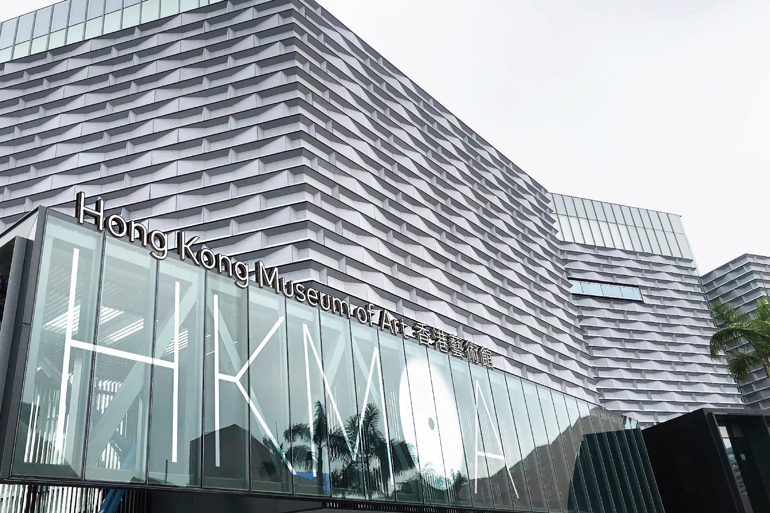Modern architectural design of the Hong Kong Museum of Art. Gray, textured façade with a glass entrance, exuding a contemporary and inviting atmosphere.