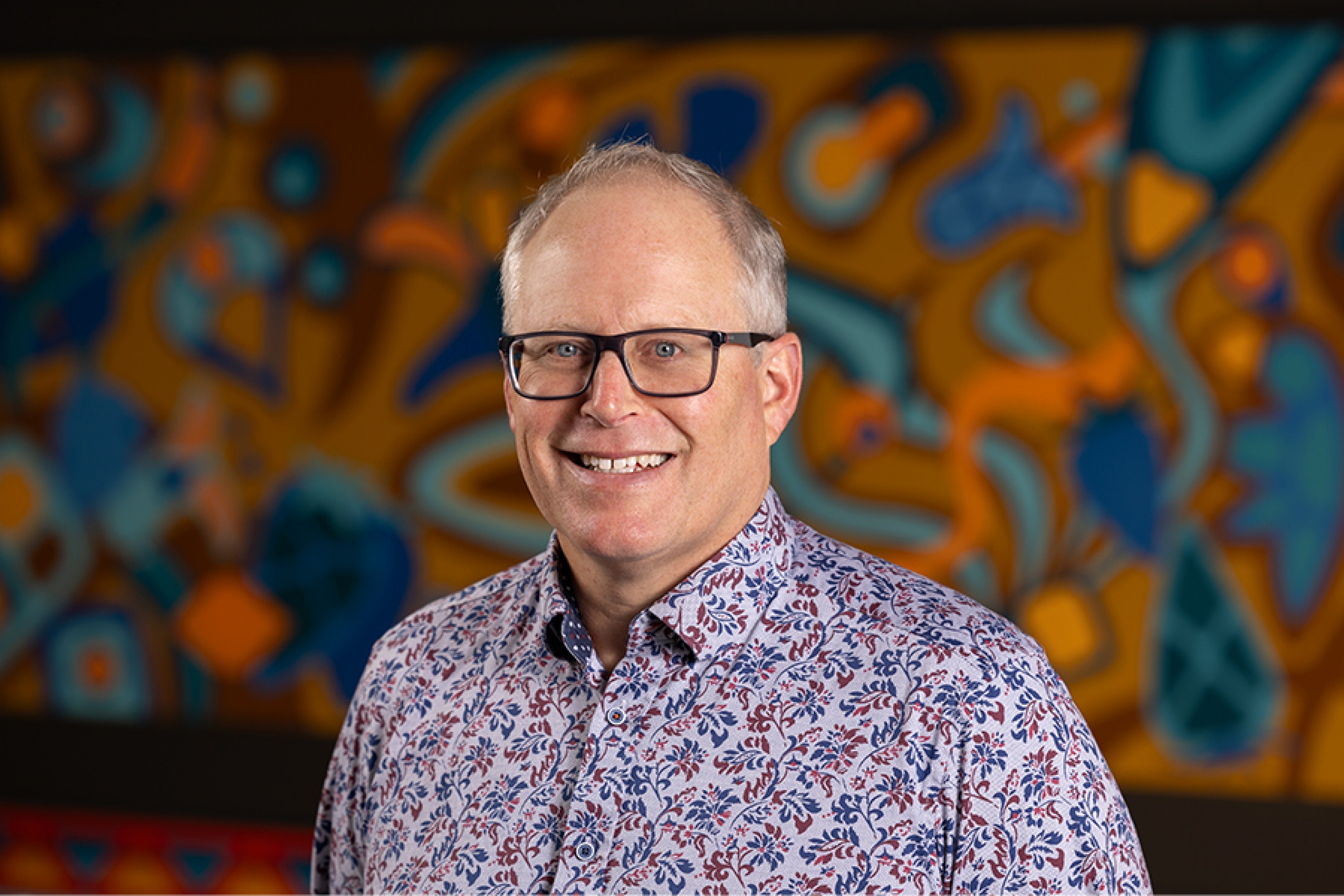 Stephen Cornish smiles at the camera in a formal portrait