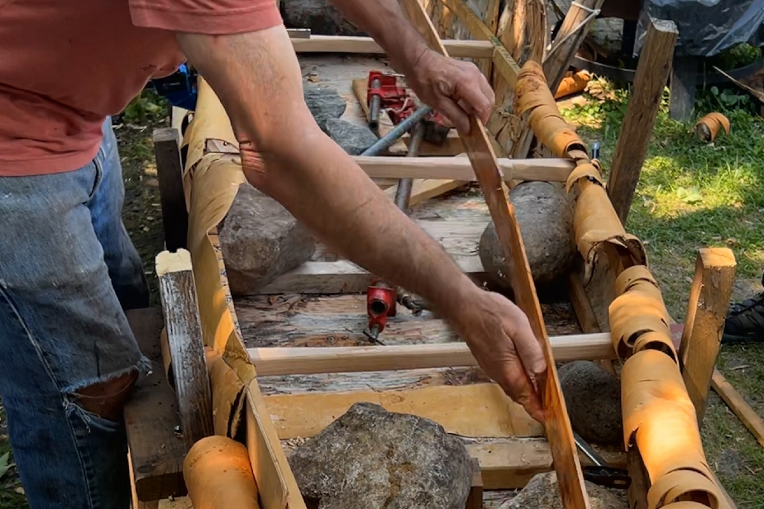 Gendron demonstrate where the cedar will be place in the interior of the canoe during the build process.