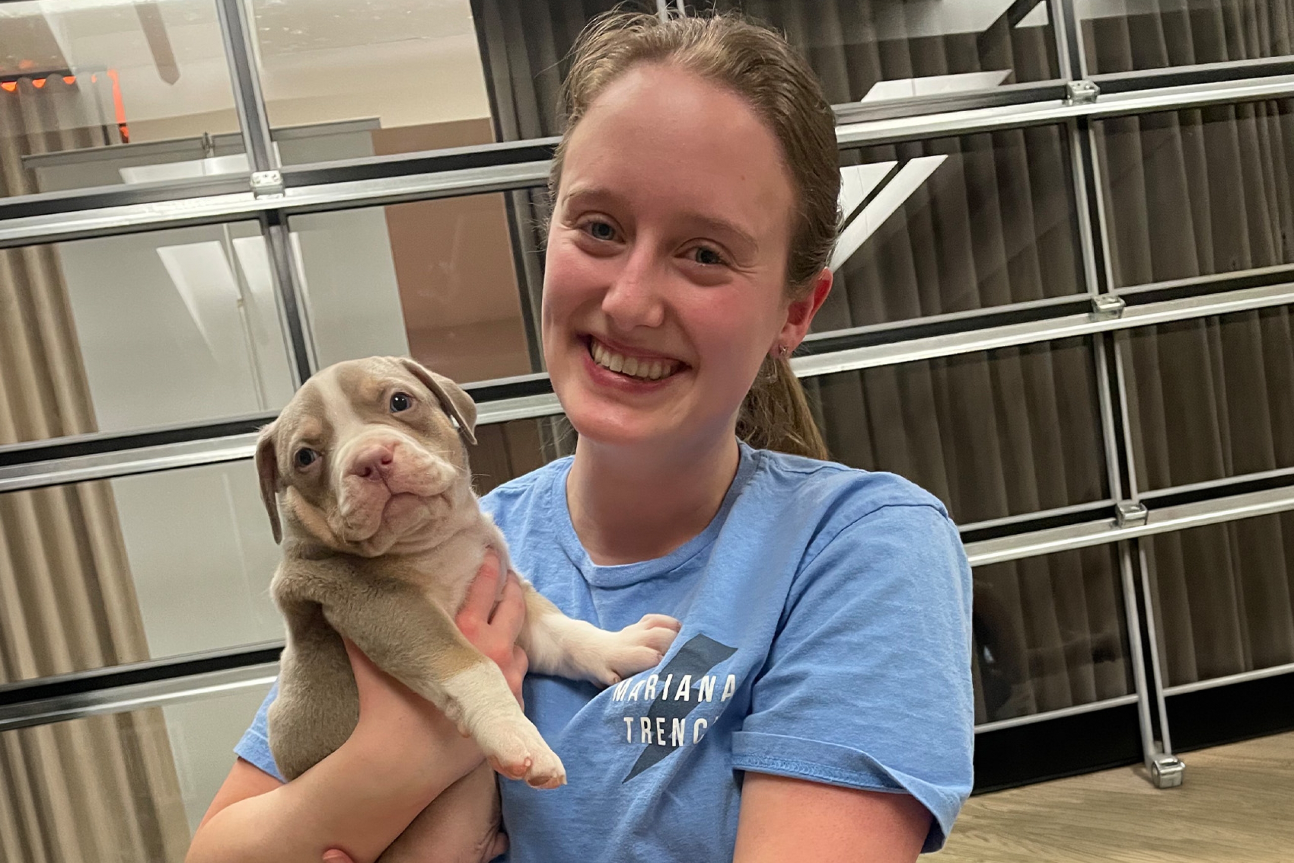 Abby Gooch smiling and holding a puppy
