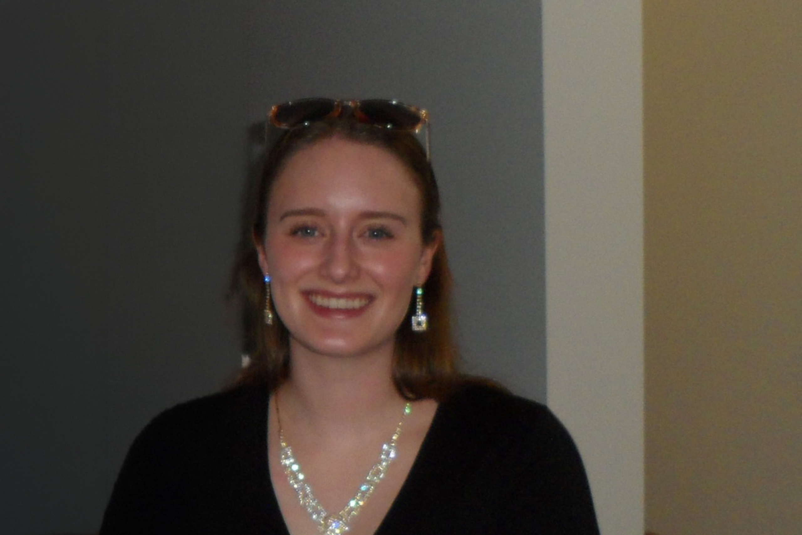 Abby Gooch standing next to a wall smiling