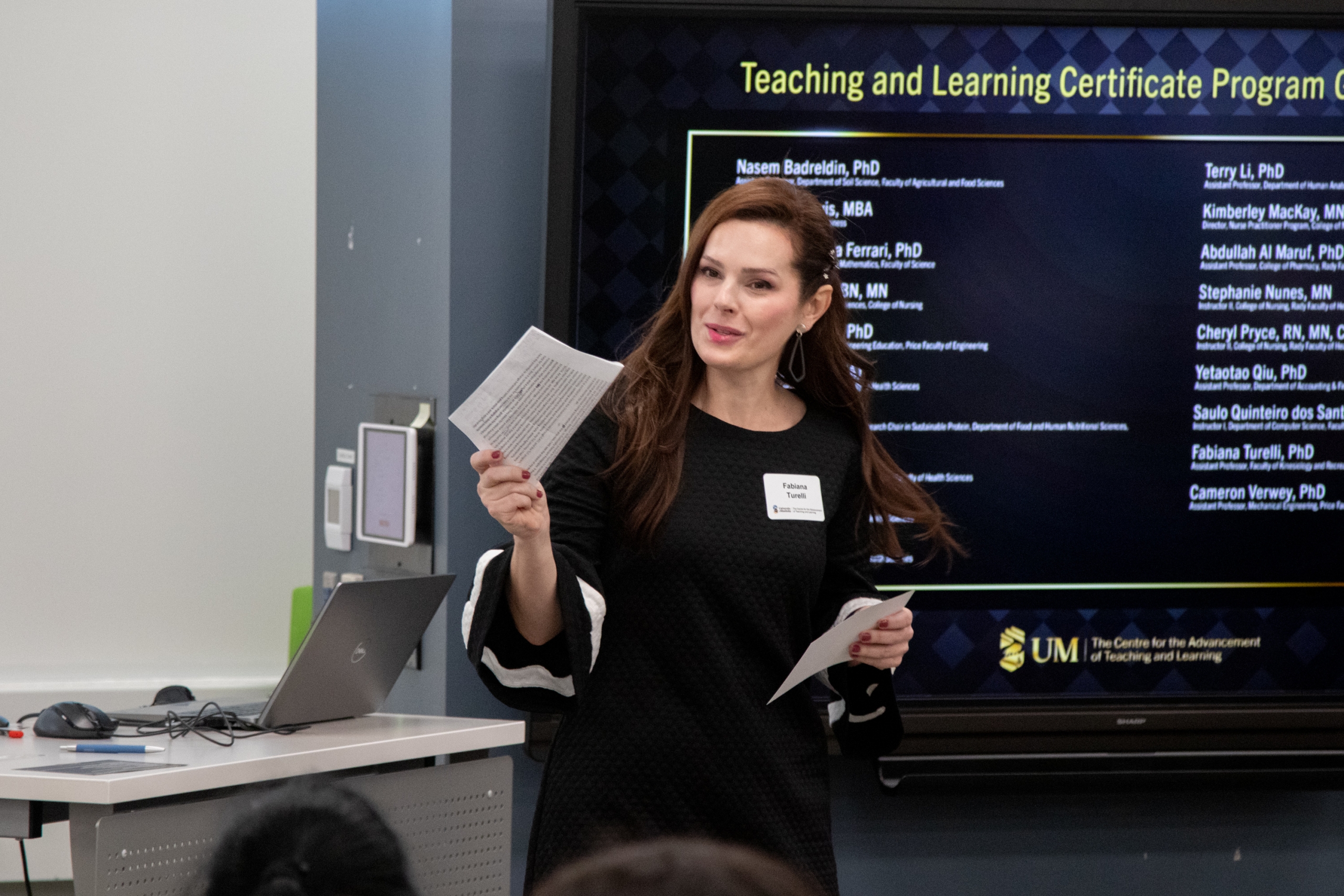 Graduating participant Fabiana Turelli gives a heartfelt speech against a backdrop listing the other graduates. 