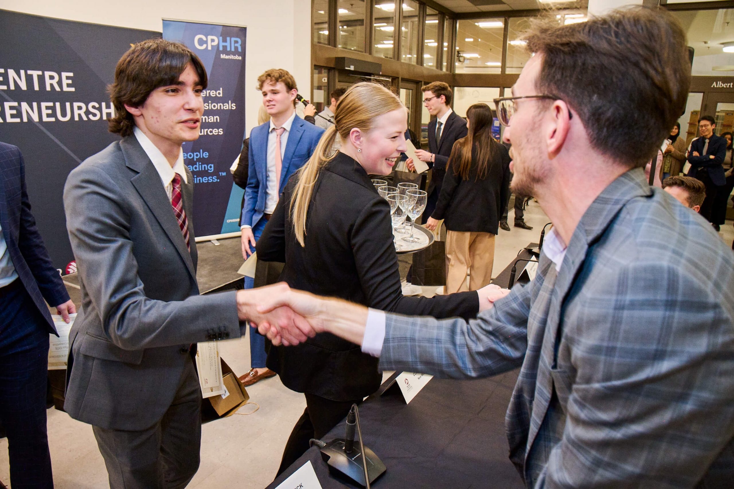 A student shakes a judge's hand