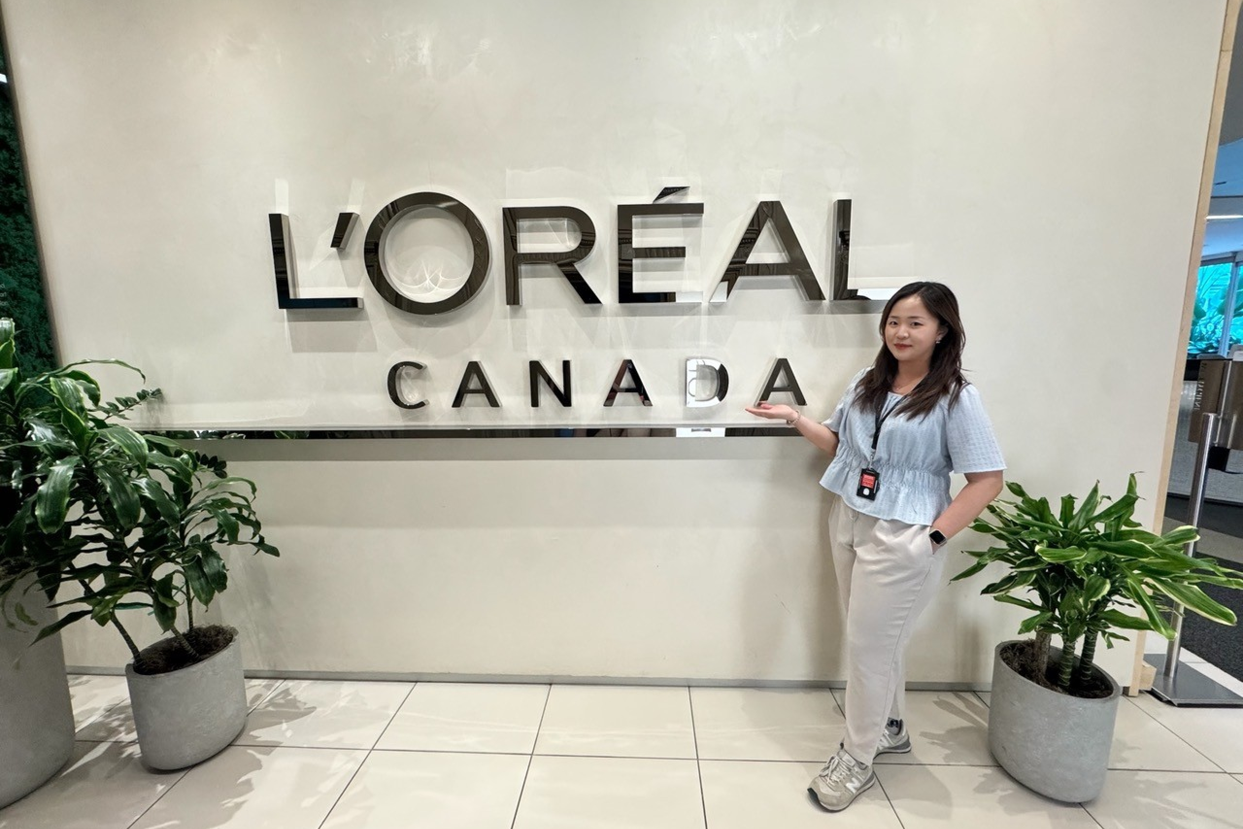 A person stands in front of a wall with a L'Oréal Canada signage.