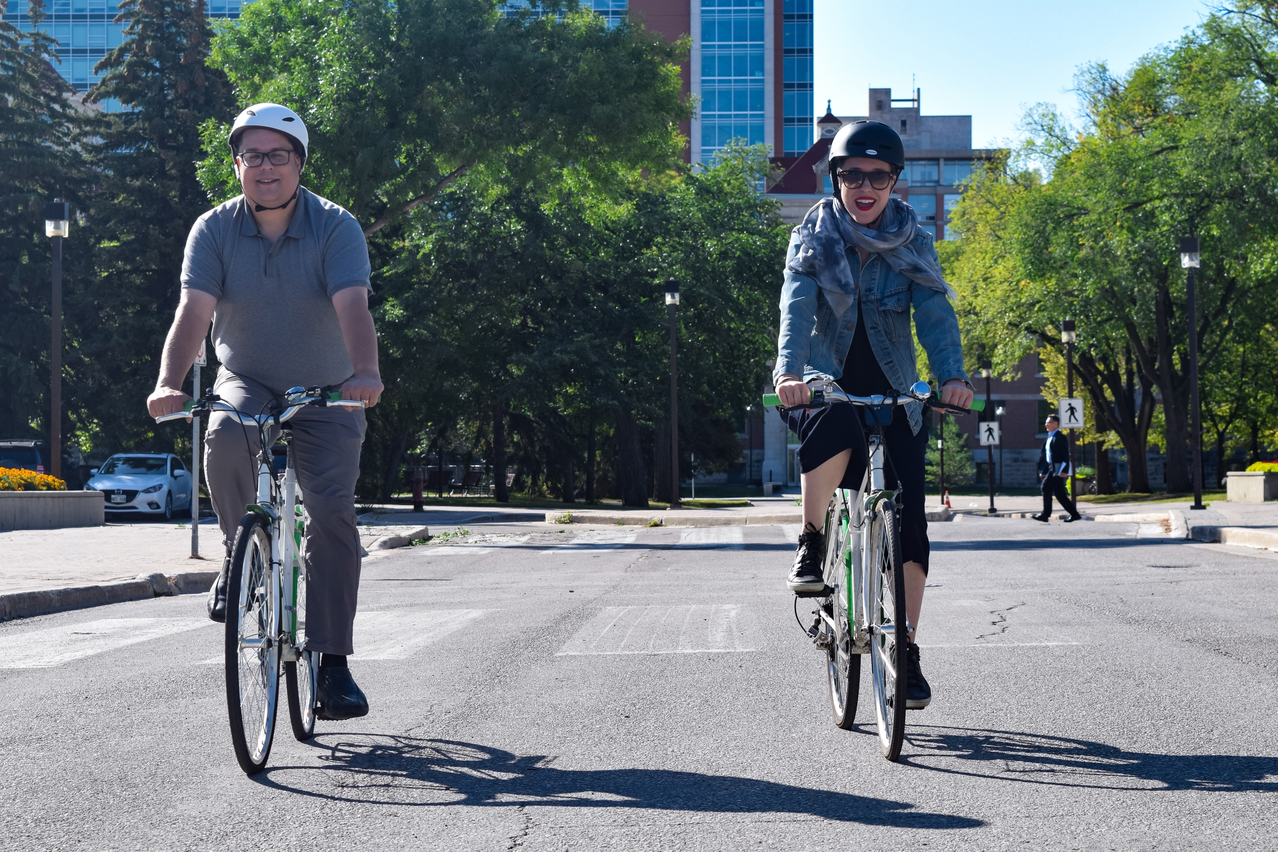 Two people enjoying Fort Garry campus by bike.