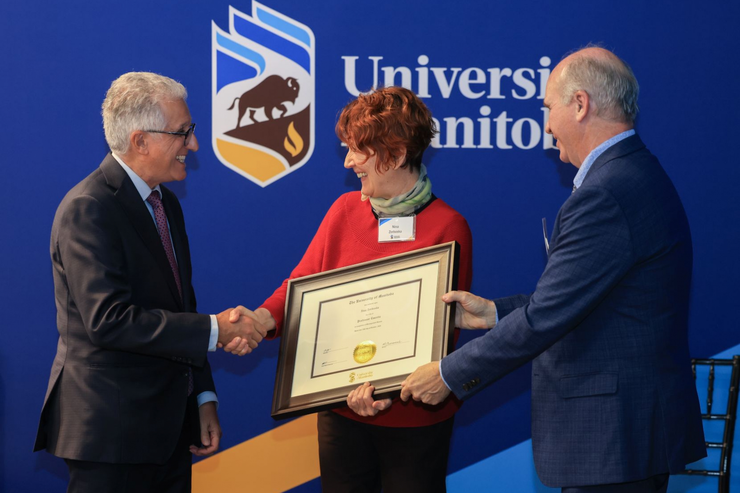 Nina Zorboska receives parchement from President Benarroch and Chancellor Angus