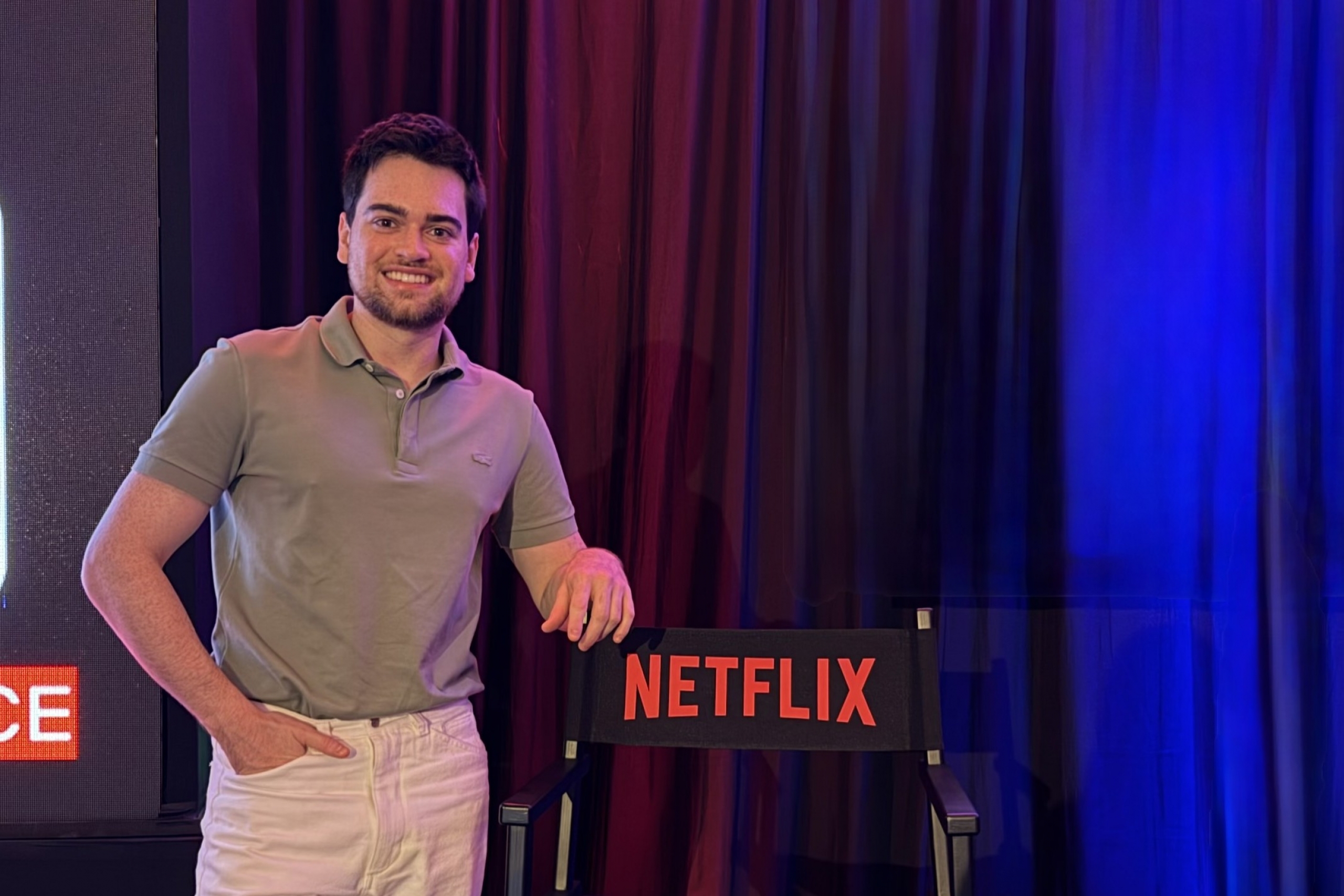 Arthur Reis stands with a Netflix director's chair
