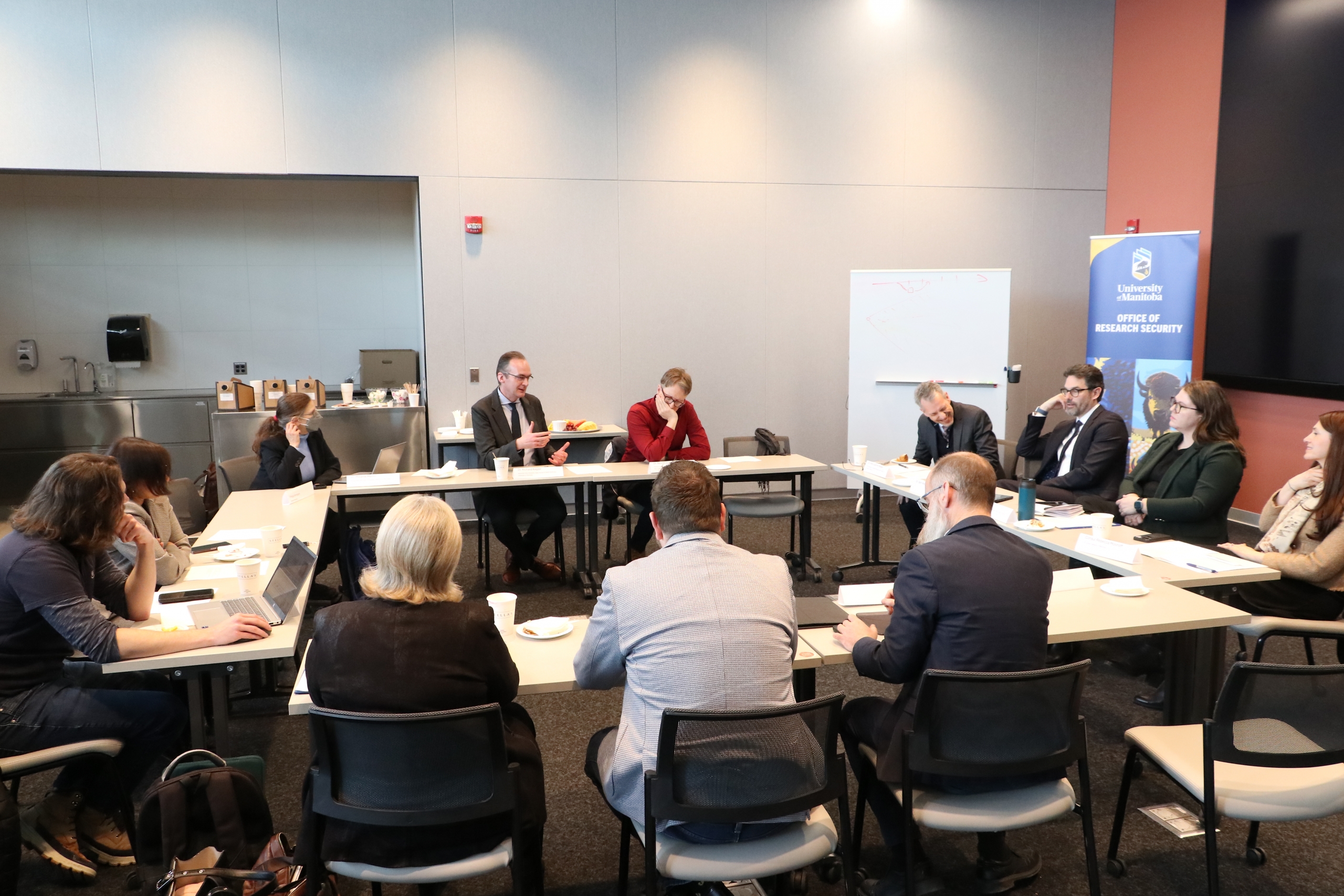 A small group engaged in roundtable discussion around a table.