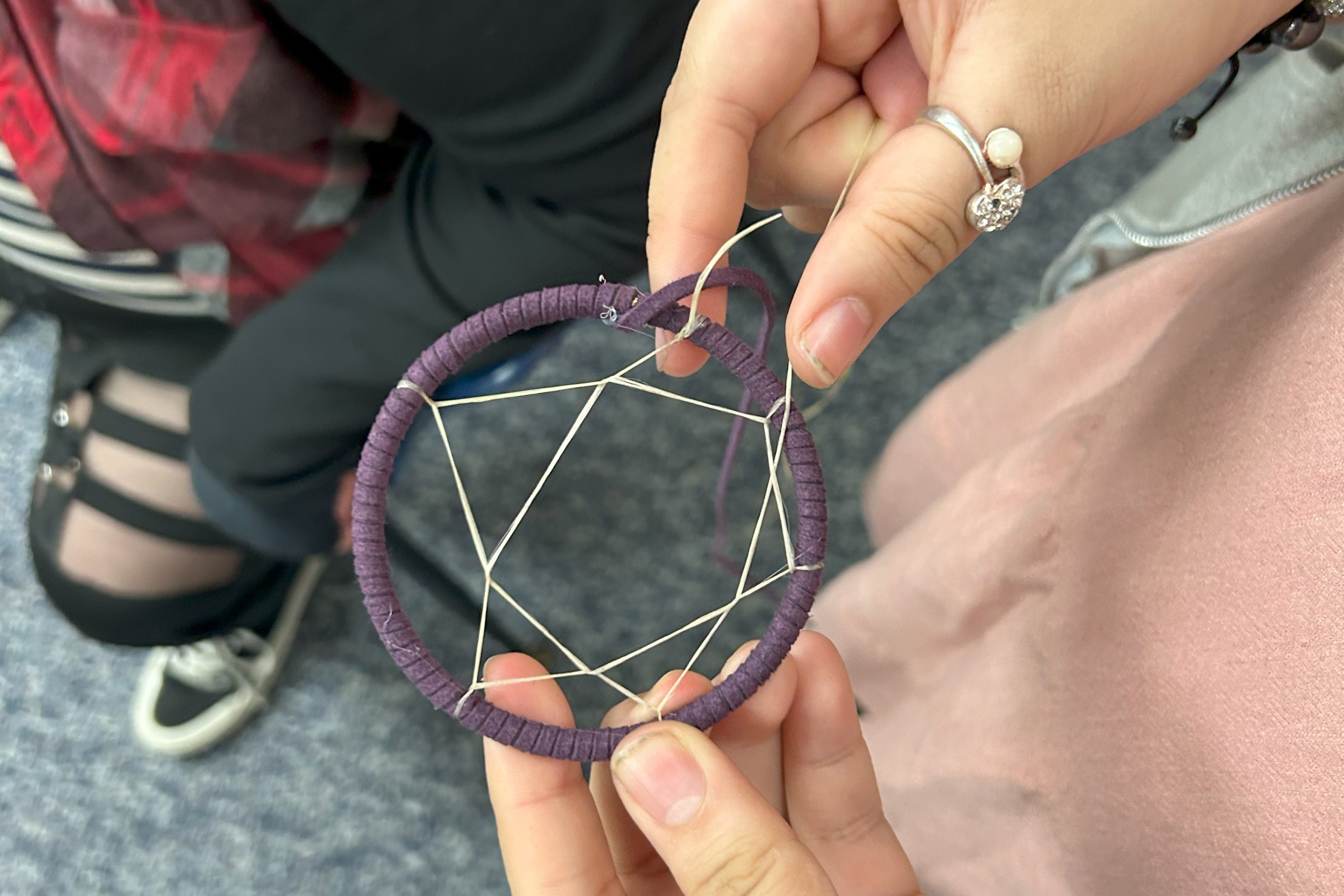 A student holds a dreamcatcher