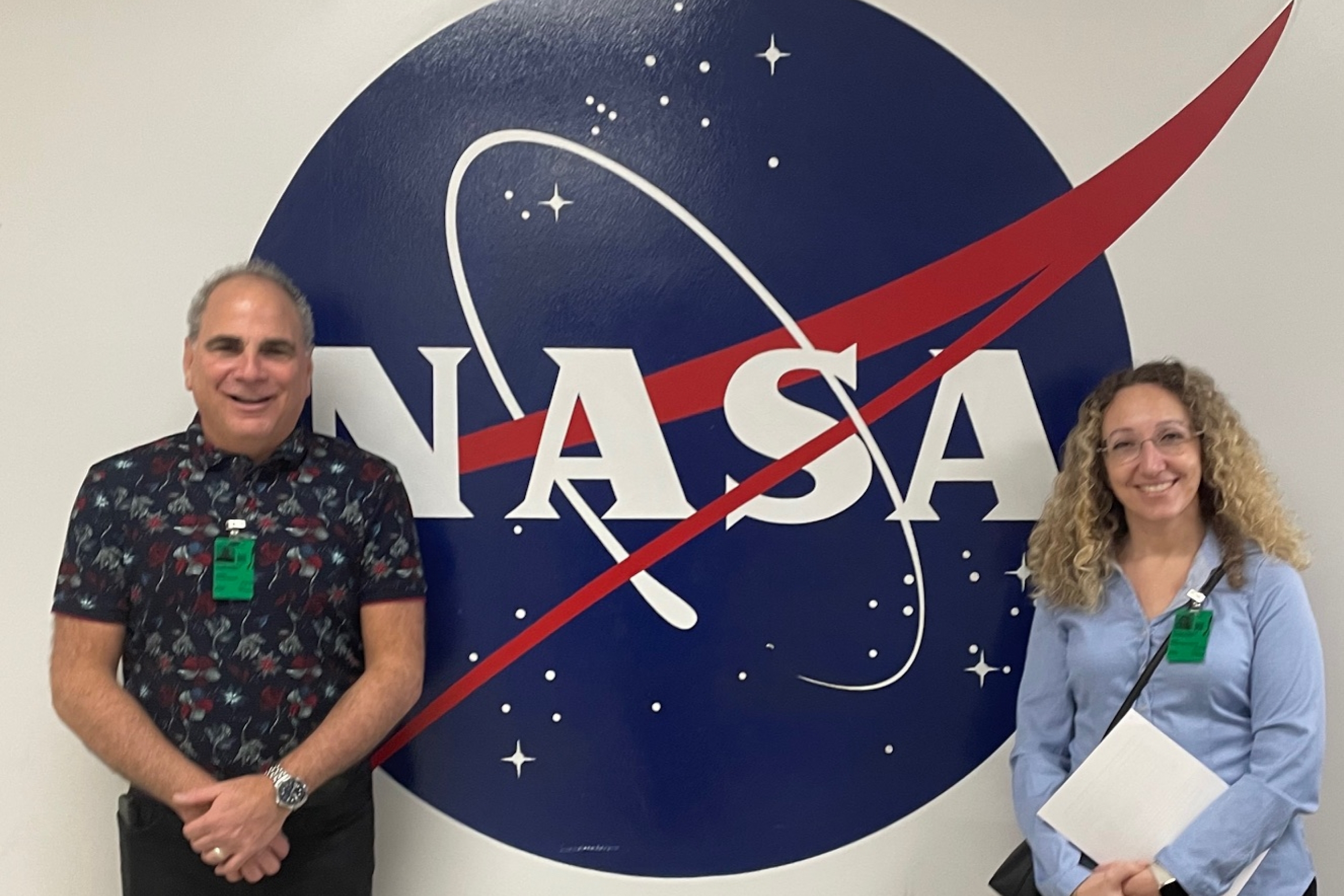 A man and woman pose with NASA logo.
