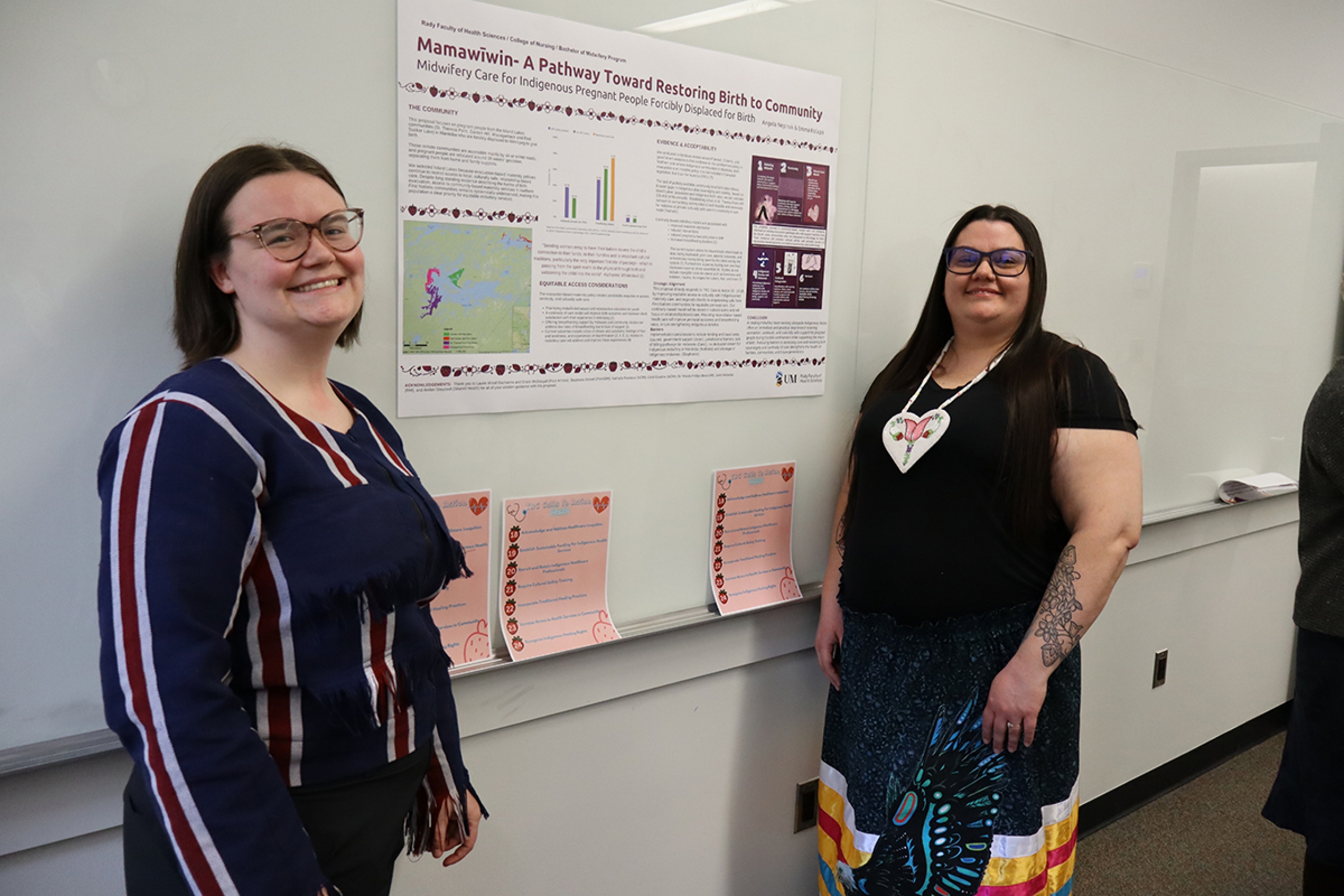 Angela Nepinak and Emma Kolapo stand with their poster.