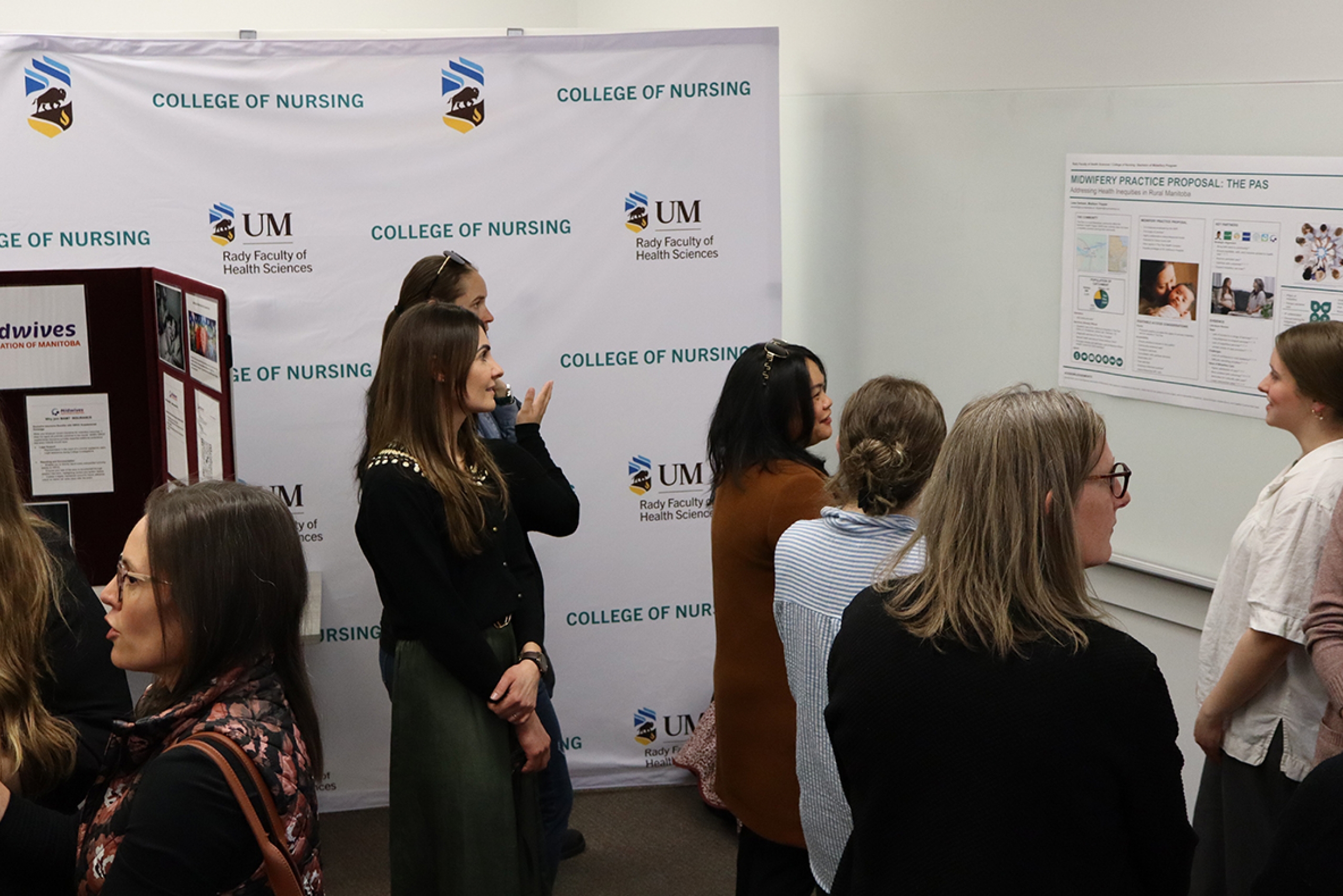 A group of people looking at a research poster.