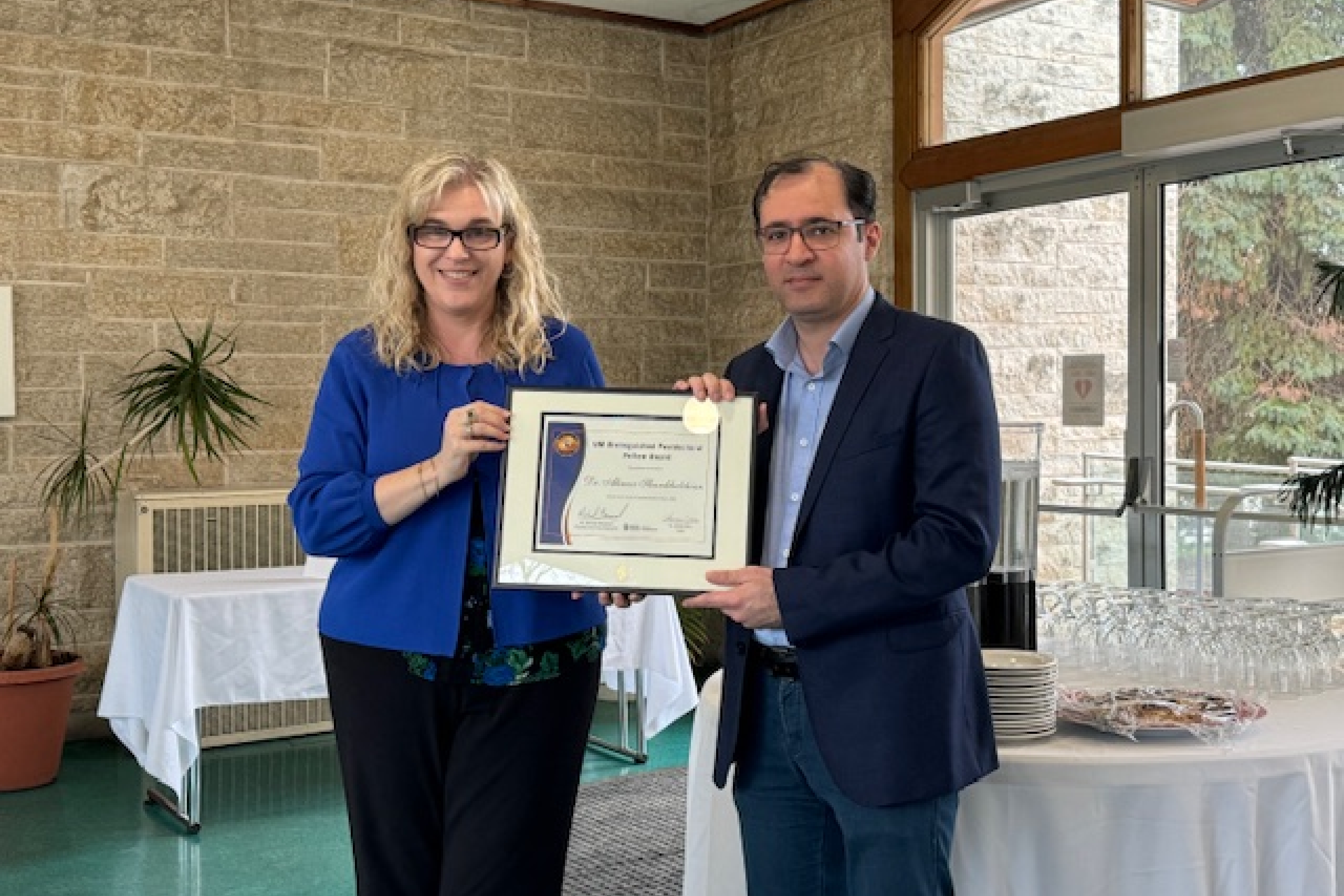 Dr. Kelley Main presents Dr. Alireza Shamkhalchian the Distinguished Postdoctoral Award.