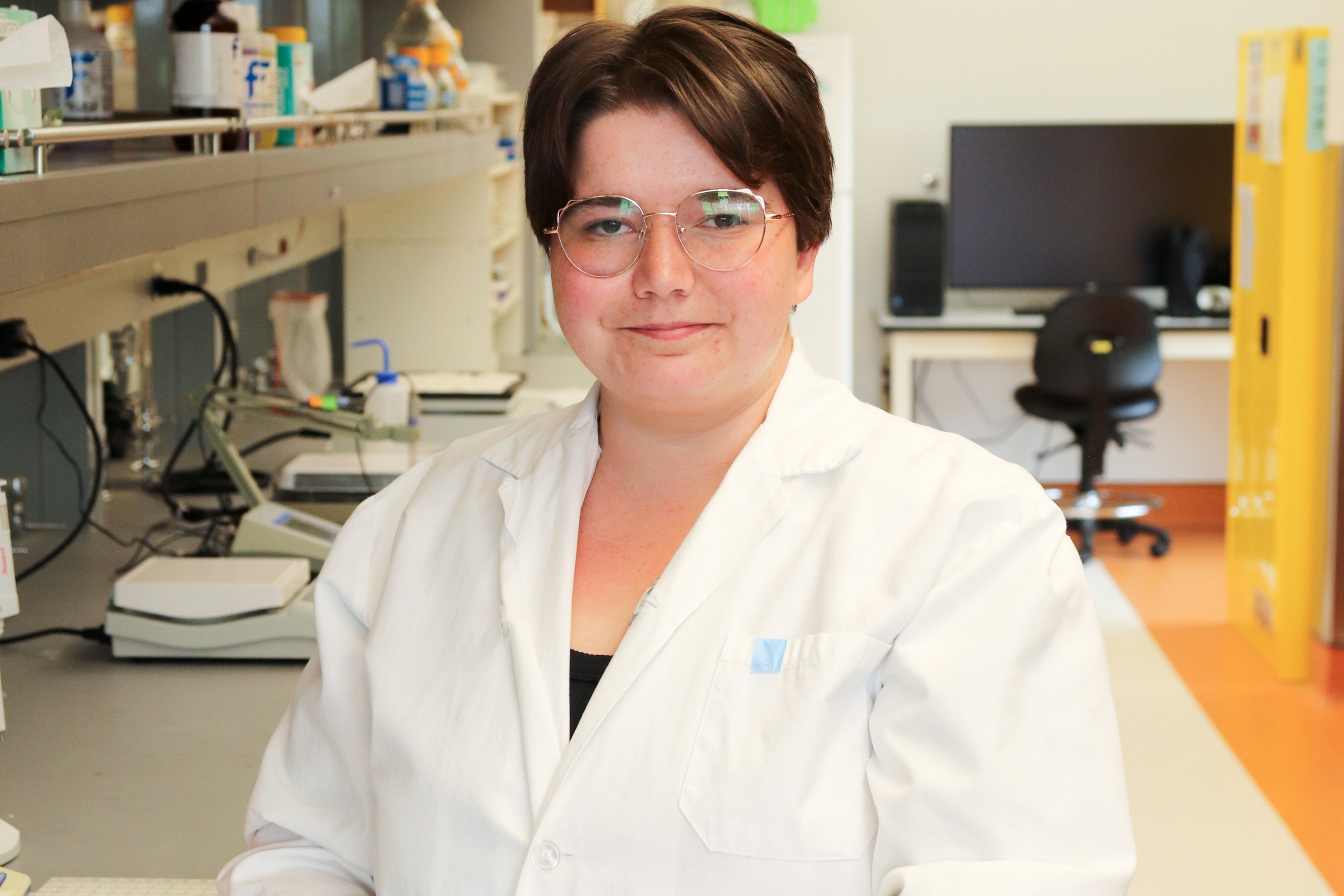 Janessa smiling at the camera inside a lab.