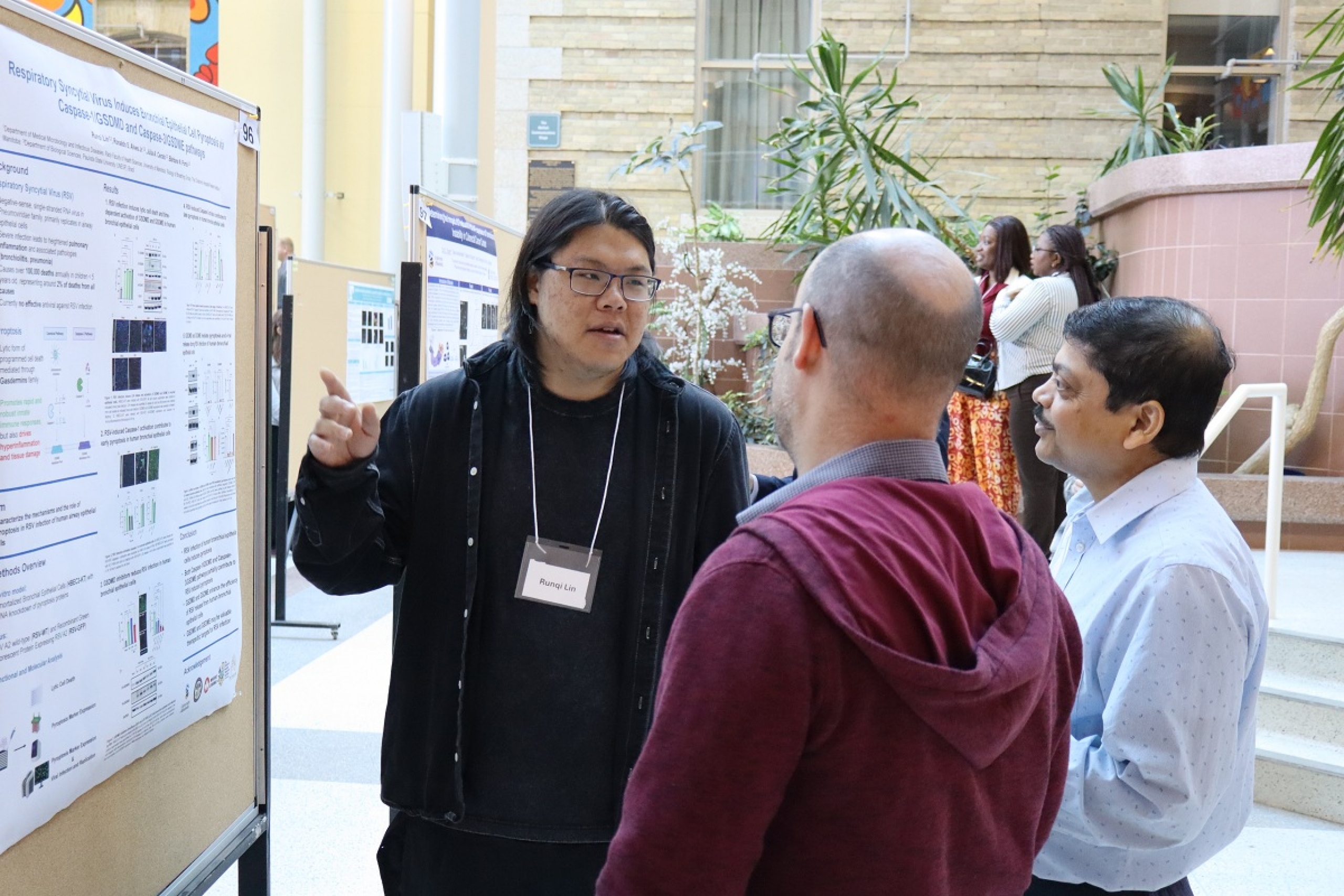 A student explains his research to a group of judges.