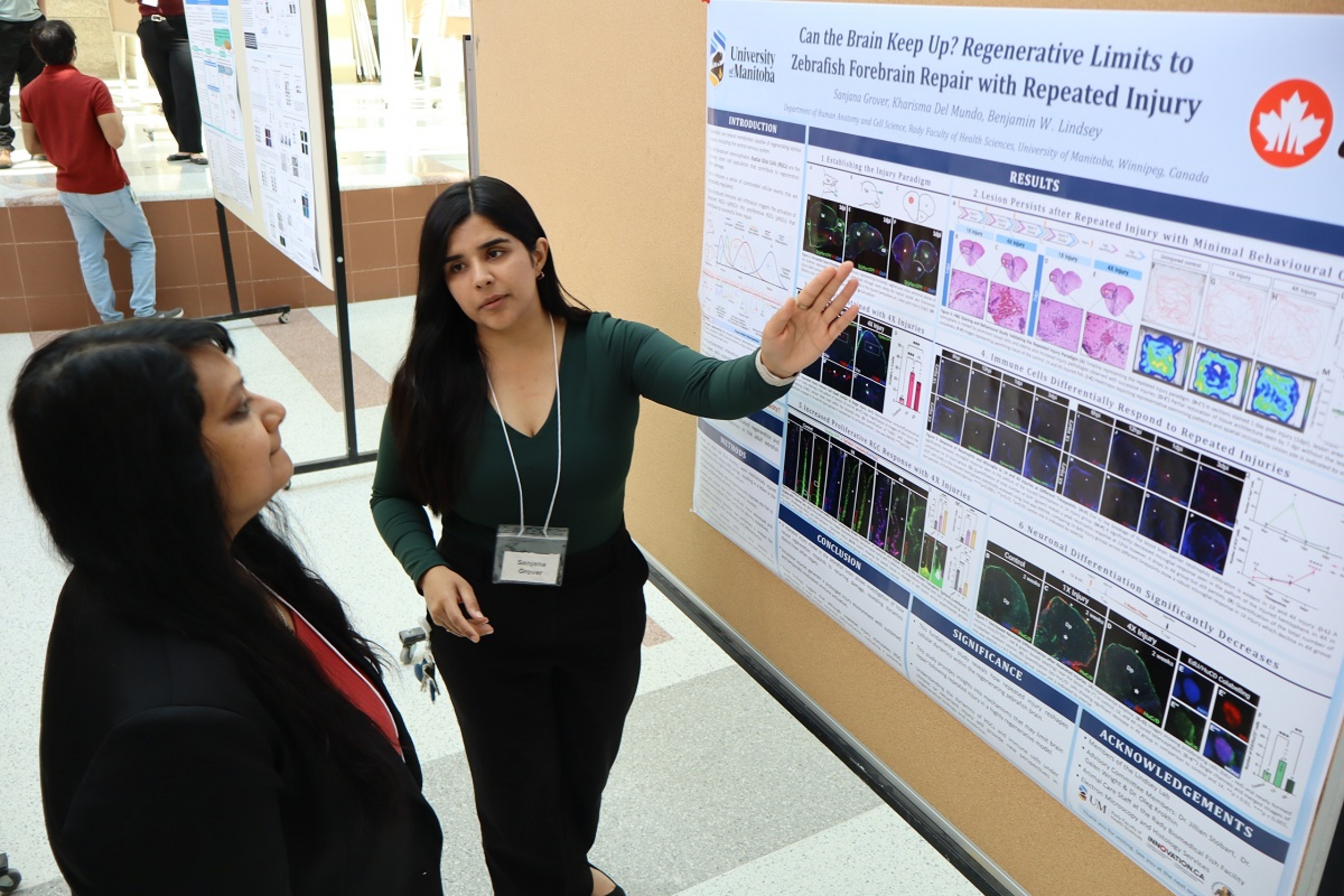 A student explains her research at a poster competition.
