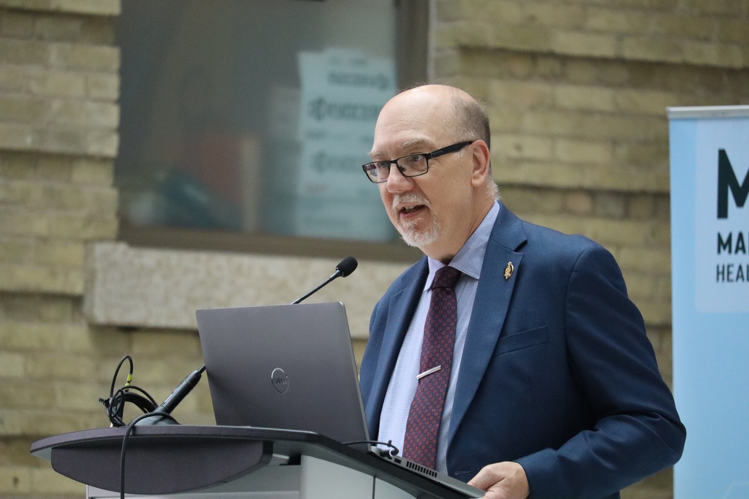 Mike Moroz, Minister of Innovation and New Technology, speaks at a podium.