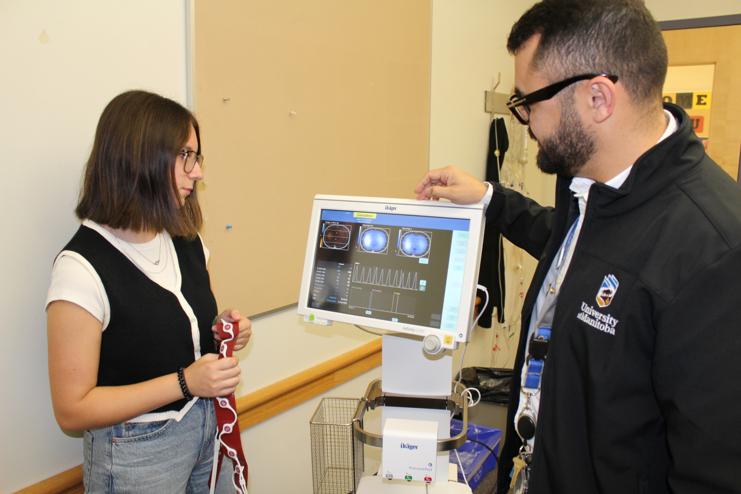 Respiratory therapy instructor Mayson Sousa demonstrates a ventilation machine to student Taylor Davidson.