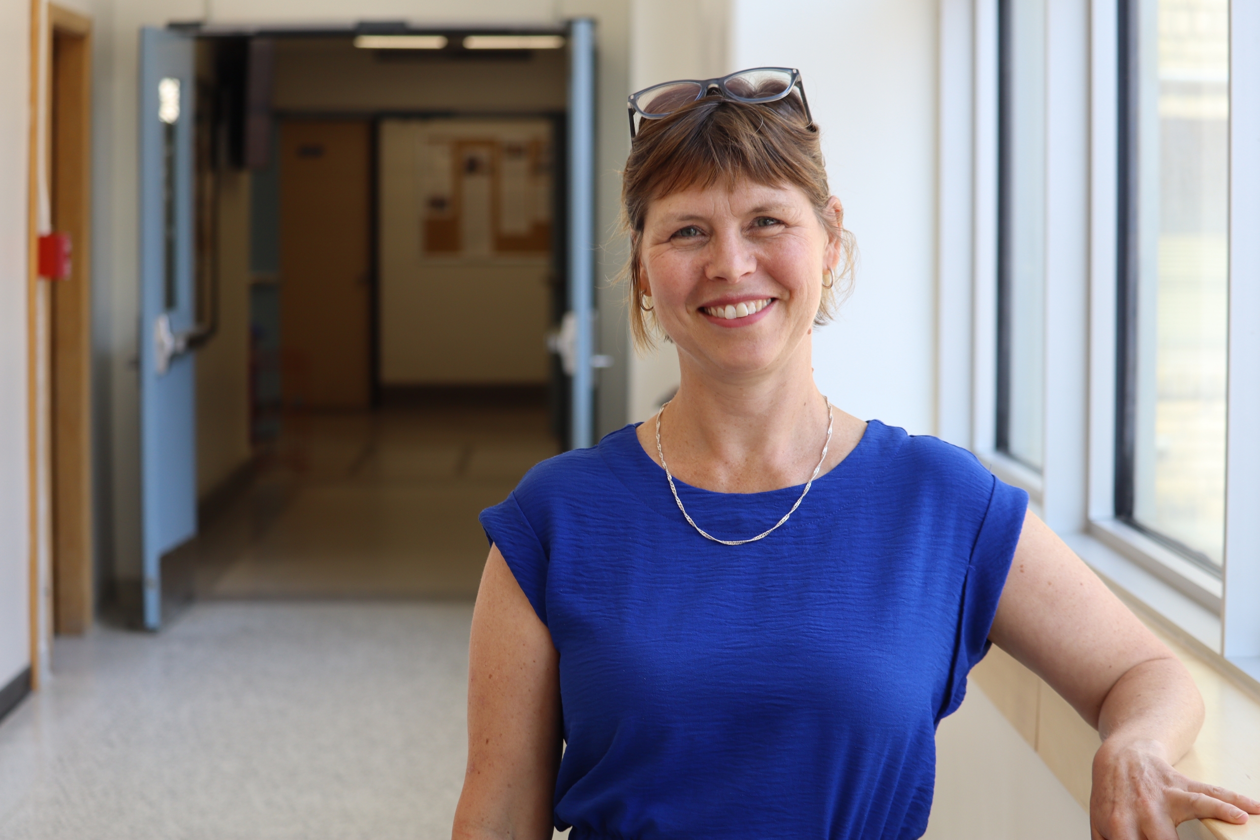 Cara Brown poses in a hallway at the College of Rehabilitation Sciences building.