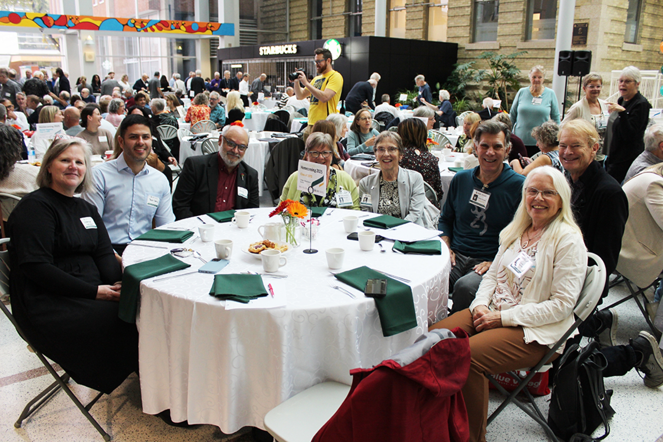 A group of alumni at a table with the dean of the College of Rehabilitation Sciences. 