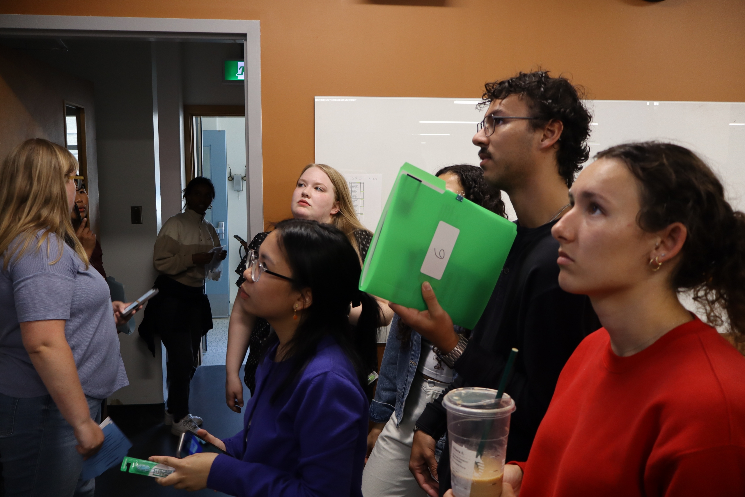 A group of students looking at a screen in a clinical area.