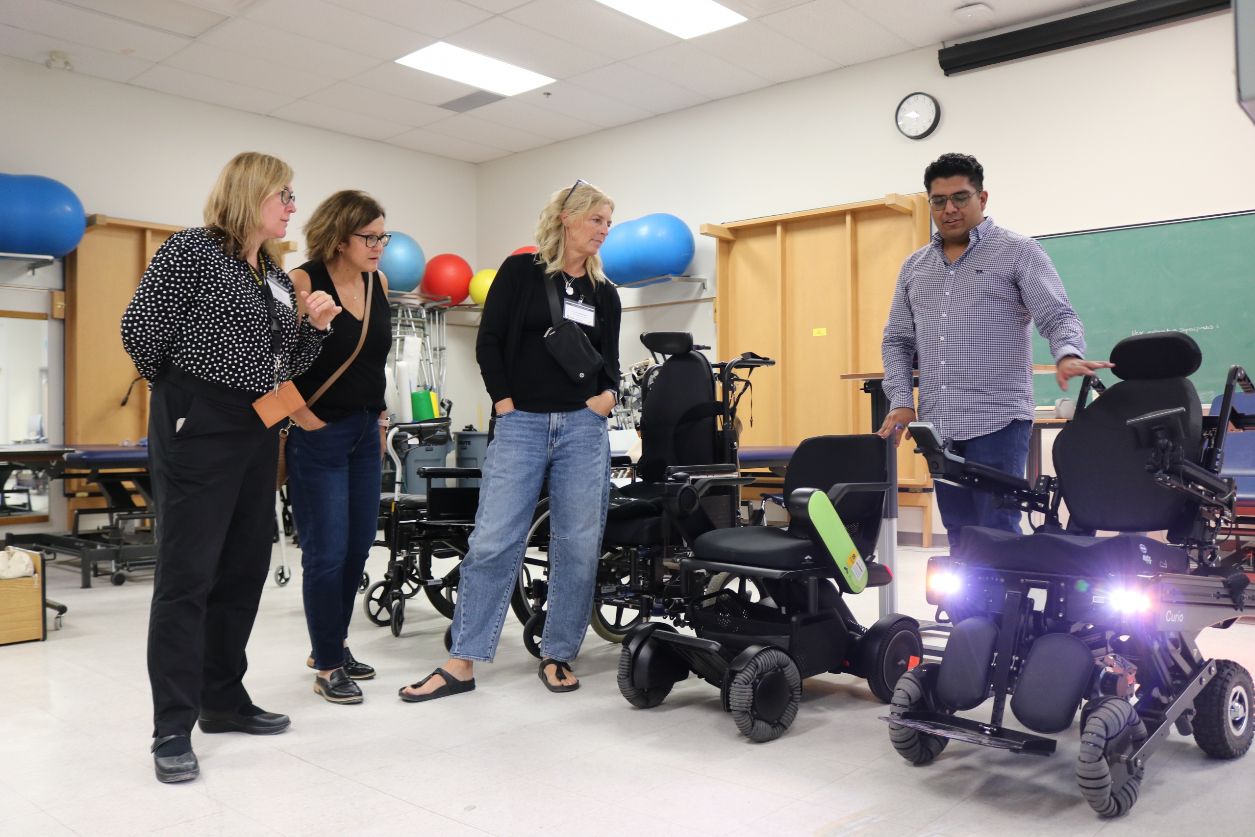 A CoRS student-researcher talks about wheelchairs with alumni.  