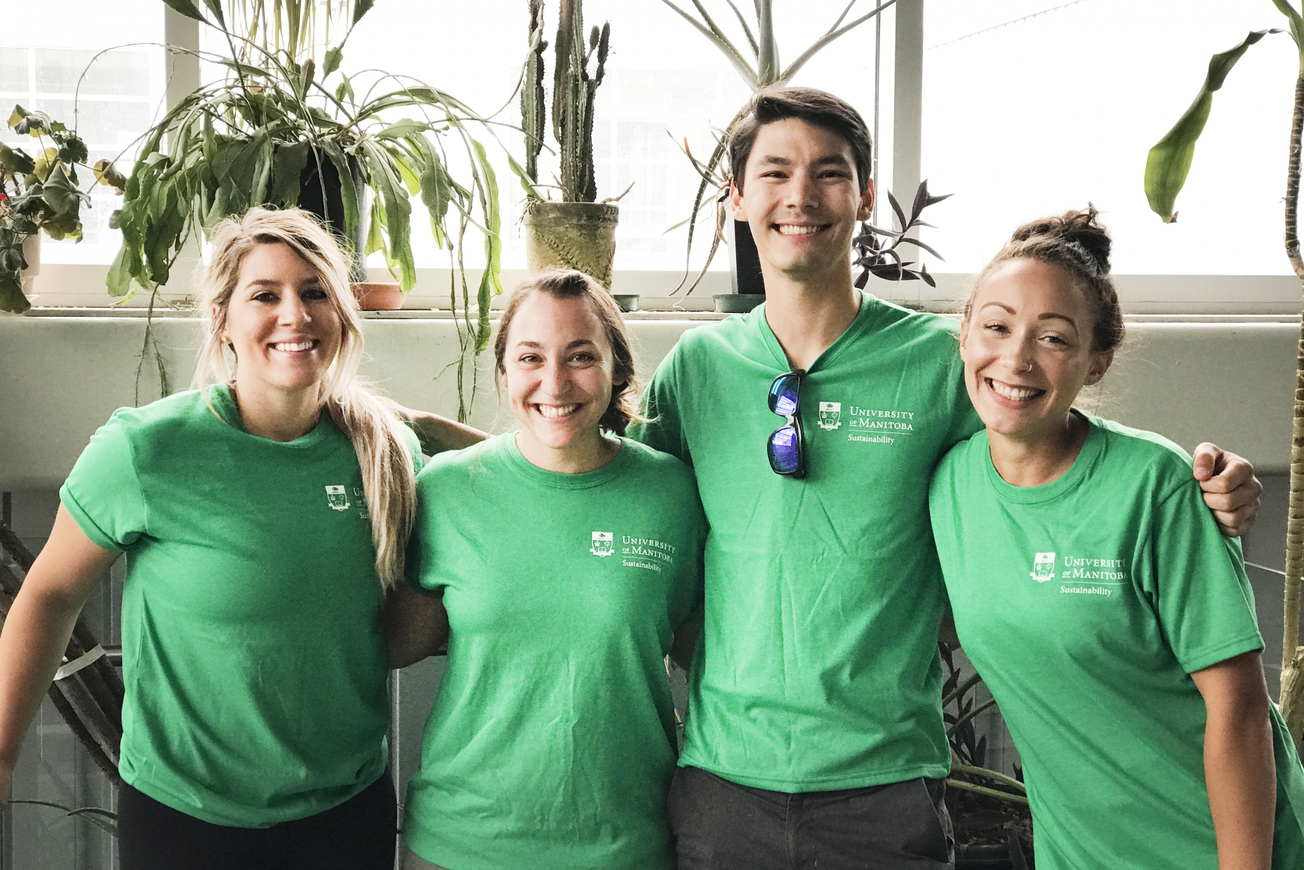 four students in green tshirts