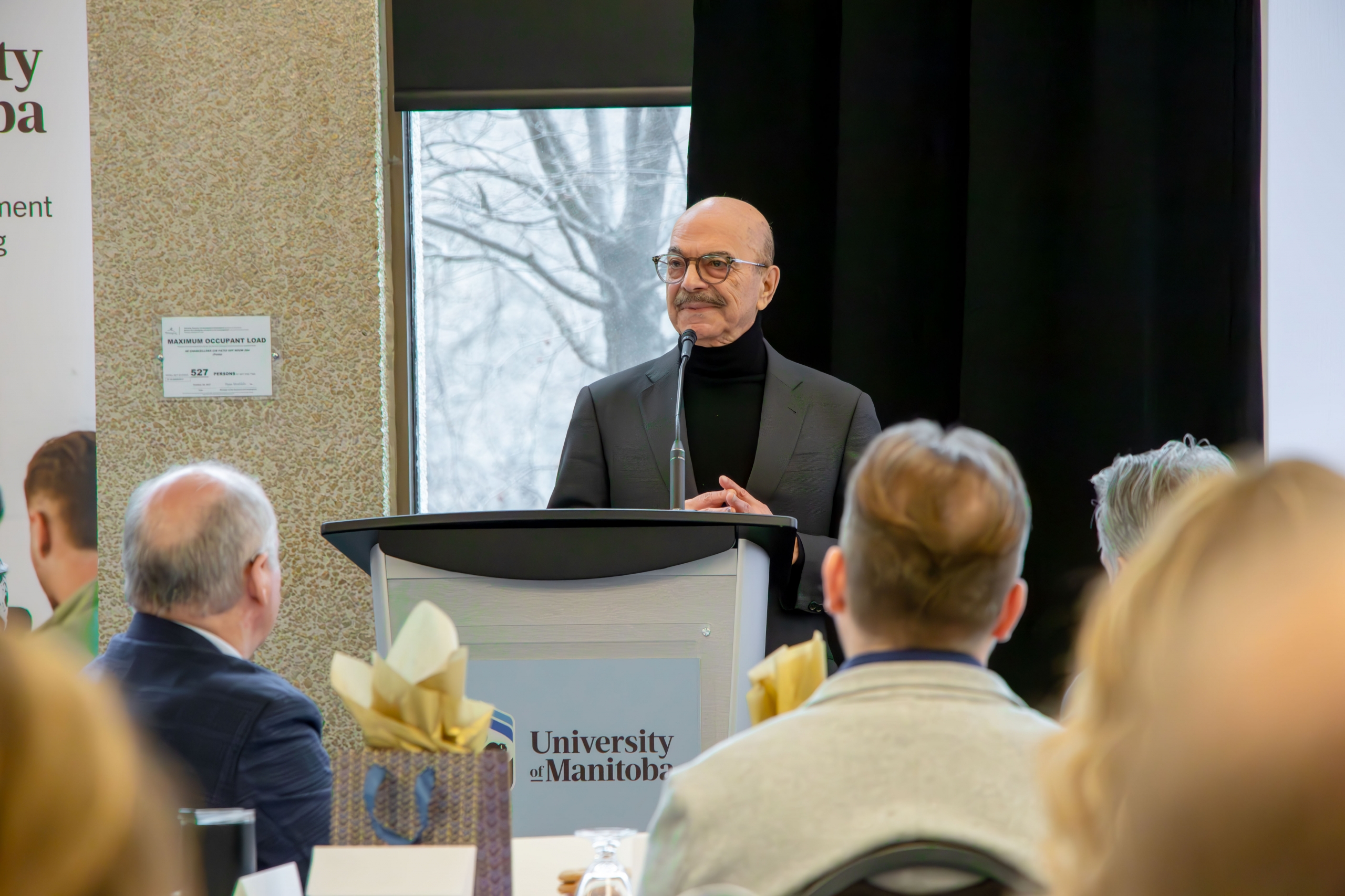 A speaker at the 2025 Faculty Symposium standing on stage.