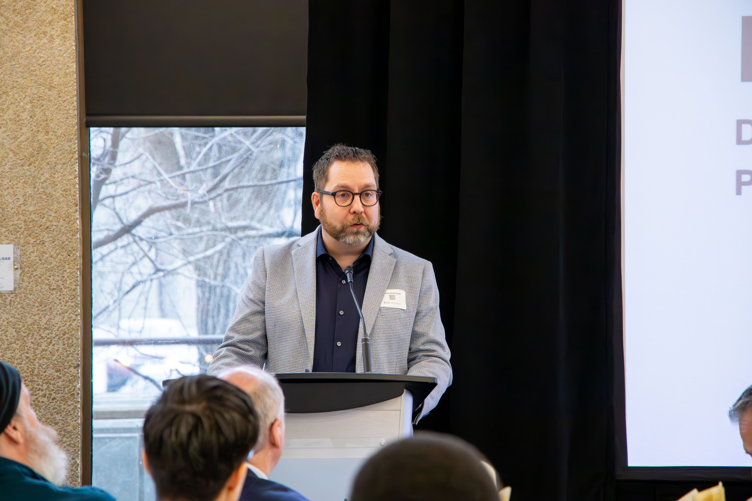A speaker at the 2025 Faculty Symposium on stage.