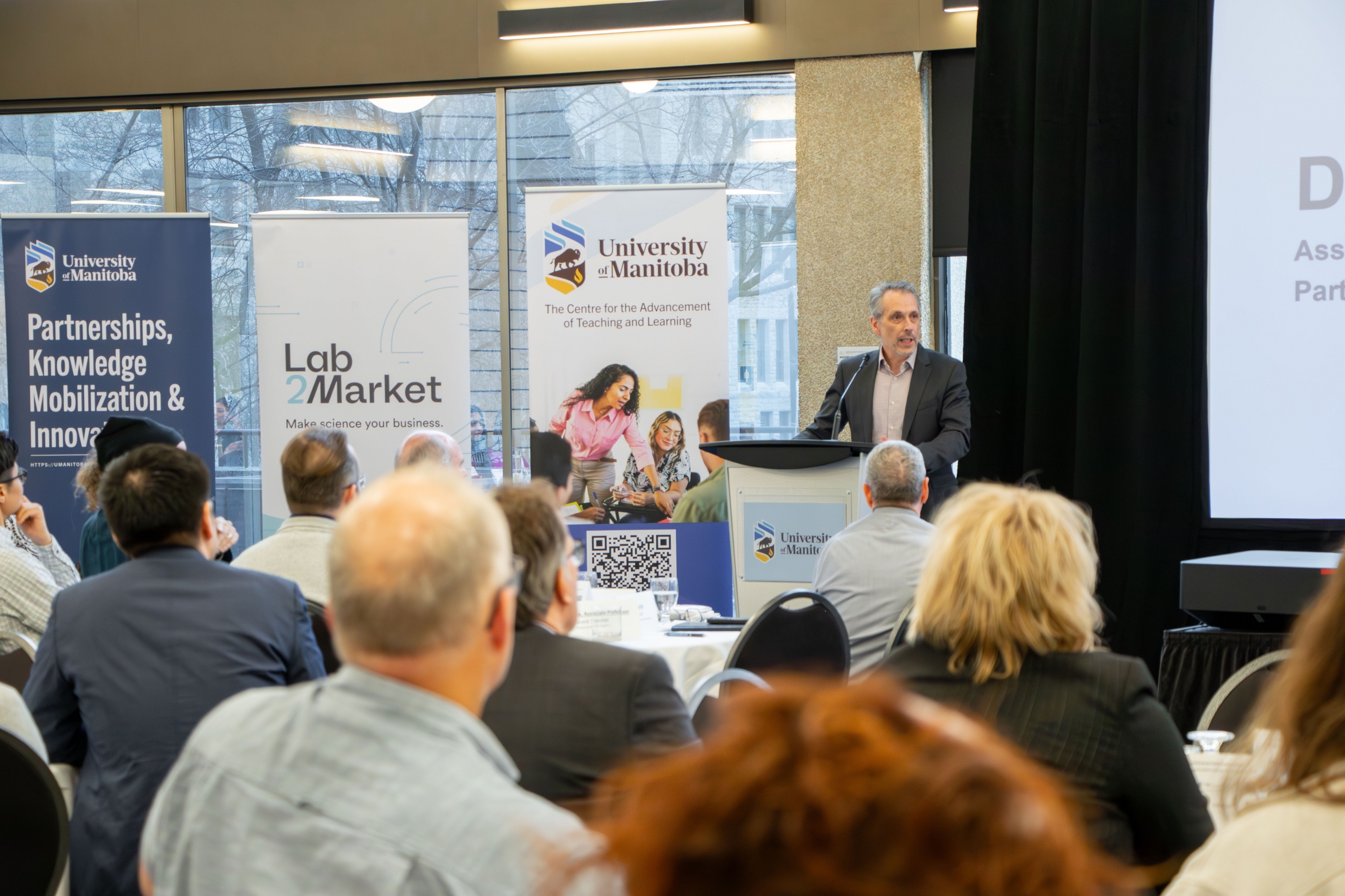 A speaker standing behind the podium and speaking to an audience.