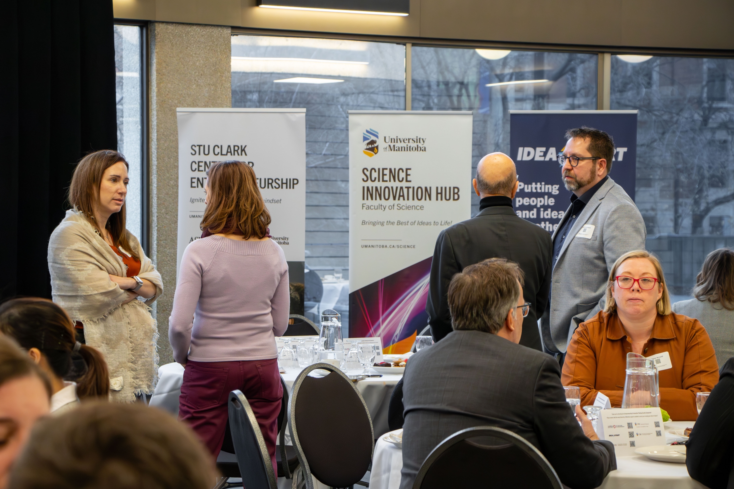 People mingling in groups at the Faculty Symposium
