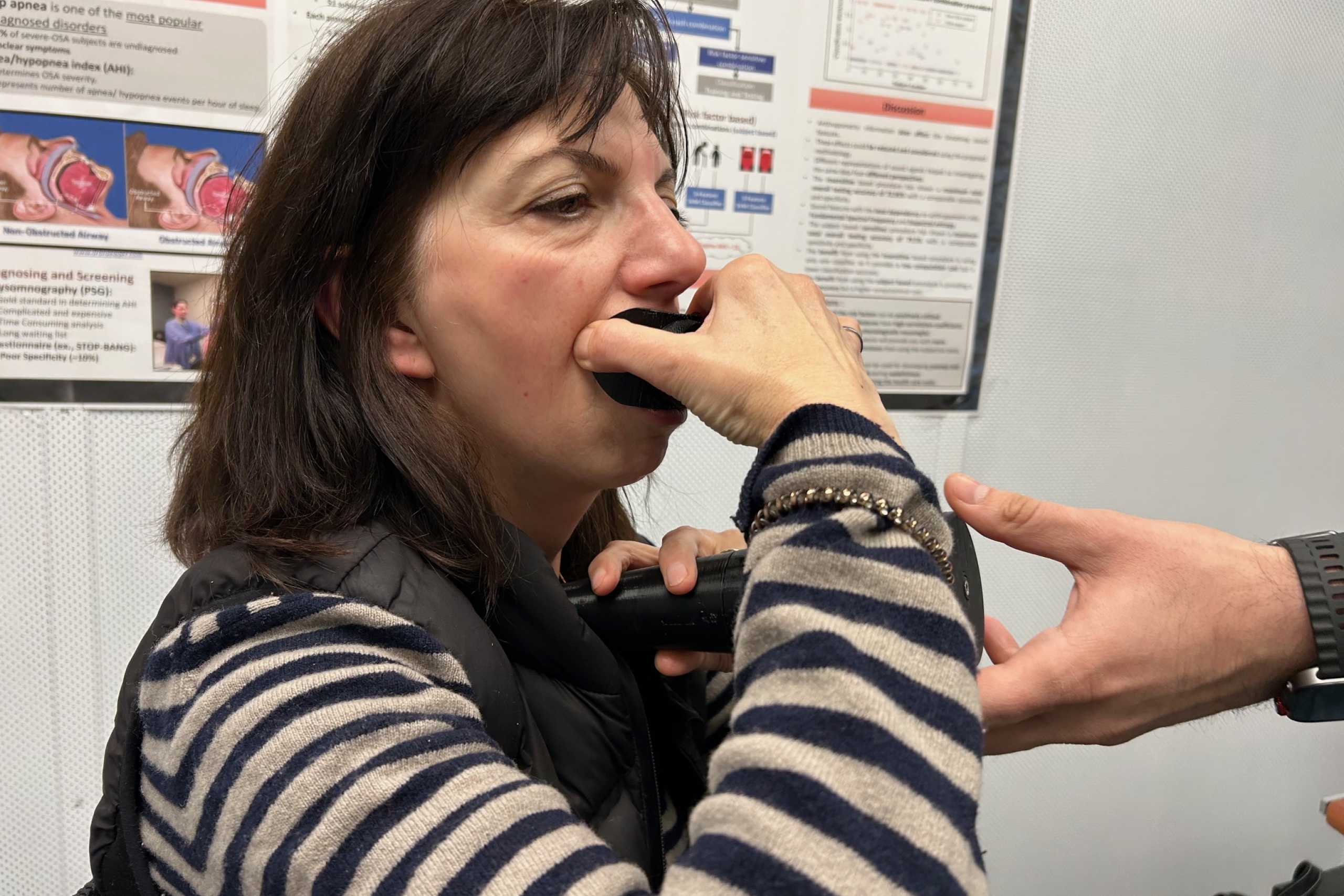 A woman demonstrates the device, holding it up to her face.
