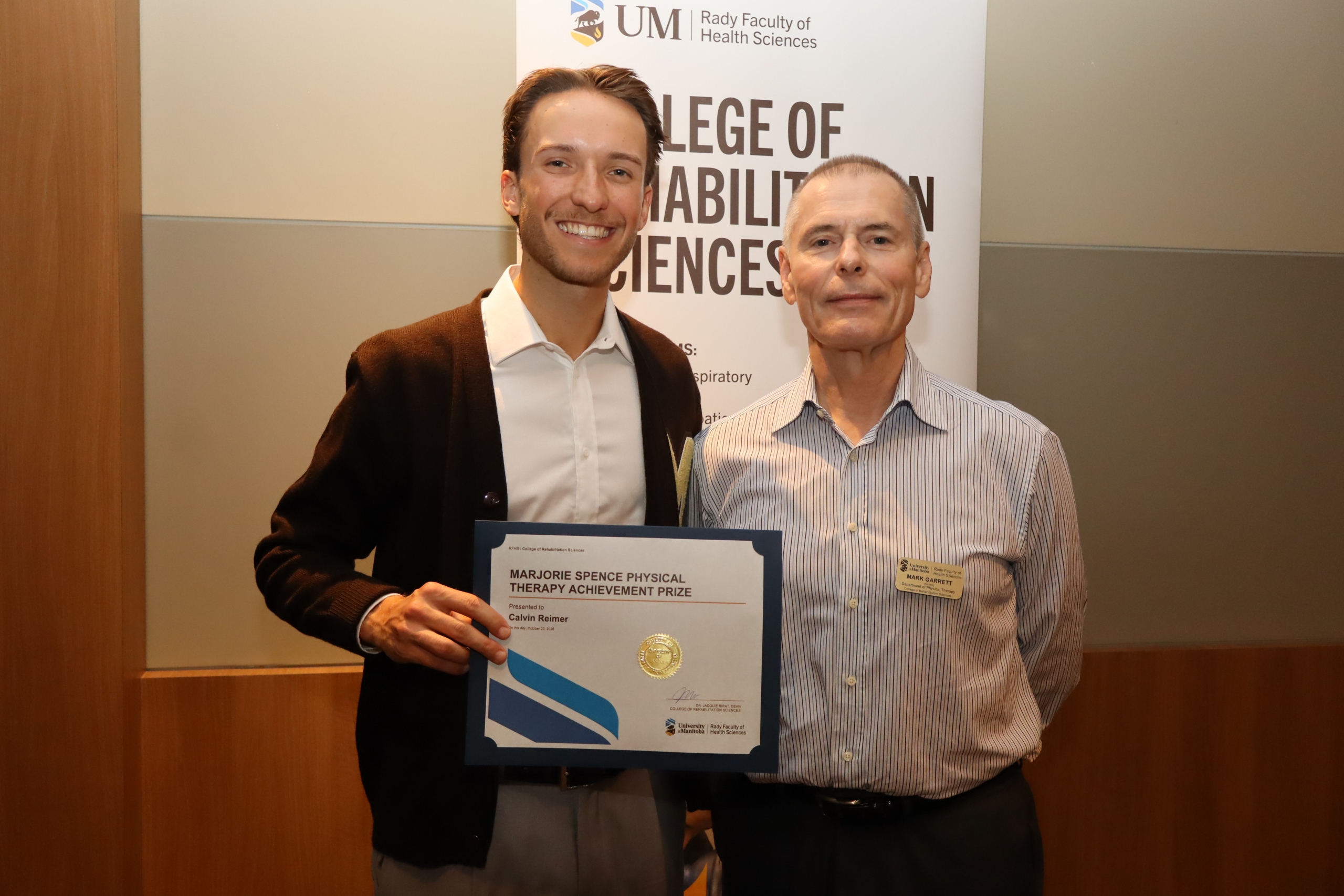 Calvin Reimer with senior instructor Mark Garrett, accepting the Marjorie Spence Physical Therapy Achievement prize.