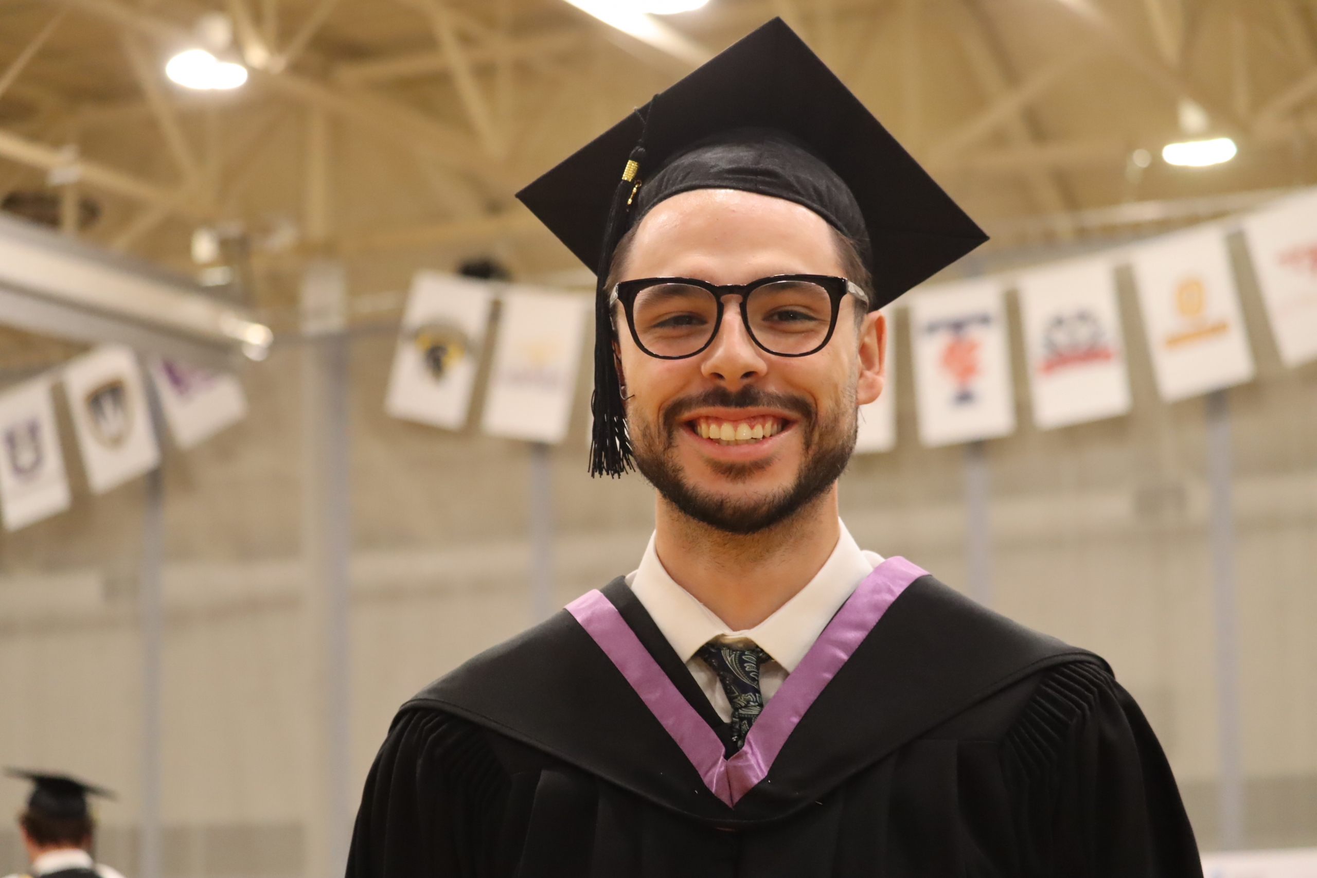 Tanner Ducharme. wearing a cap and gown for convocation.