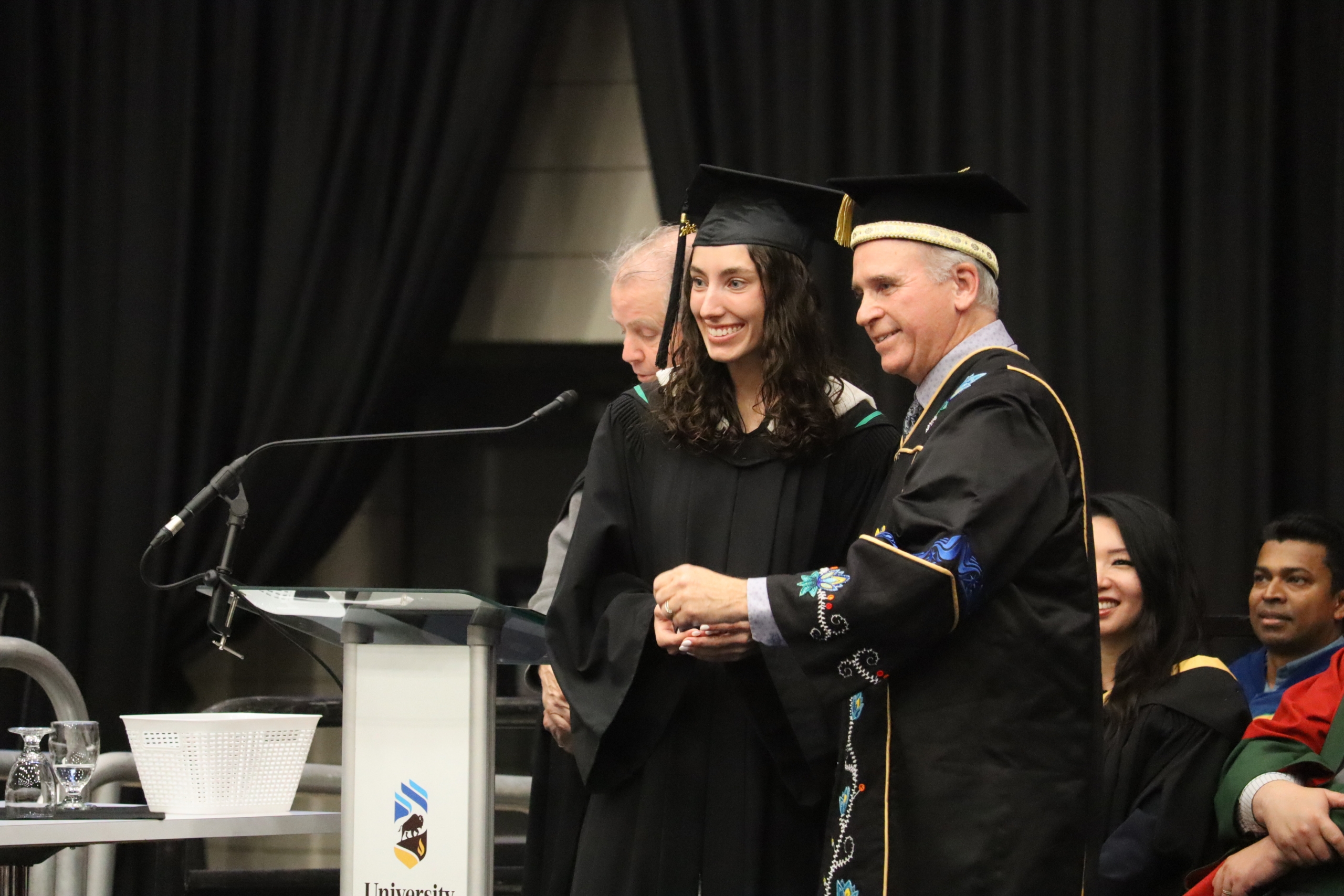 Chancellor Dave Angus presents Emily Firth with her UM Gold Medal award.