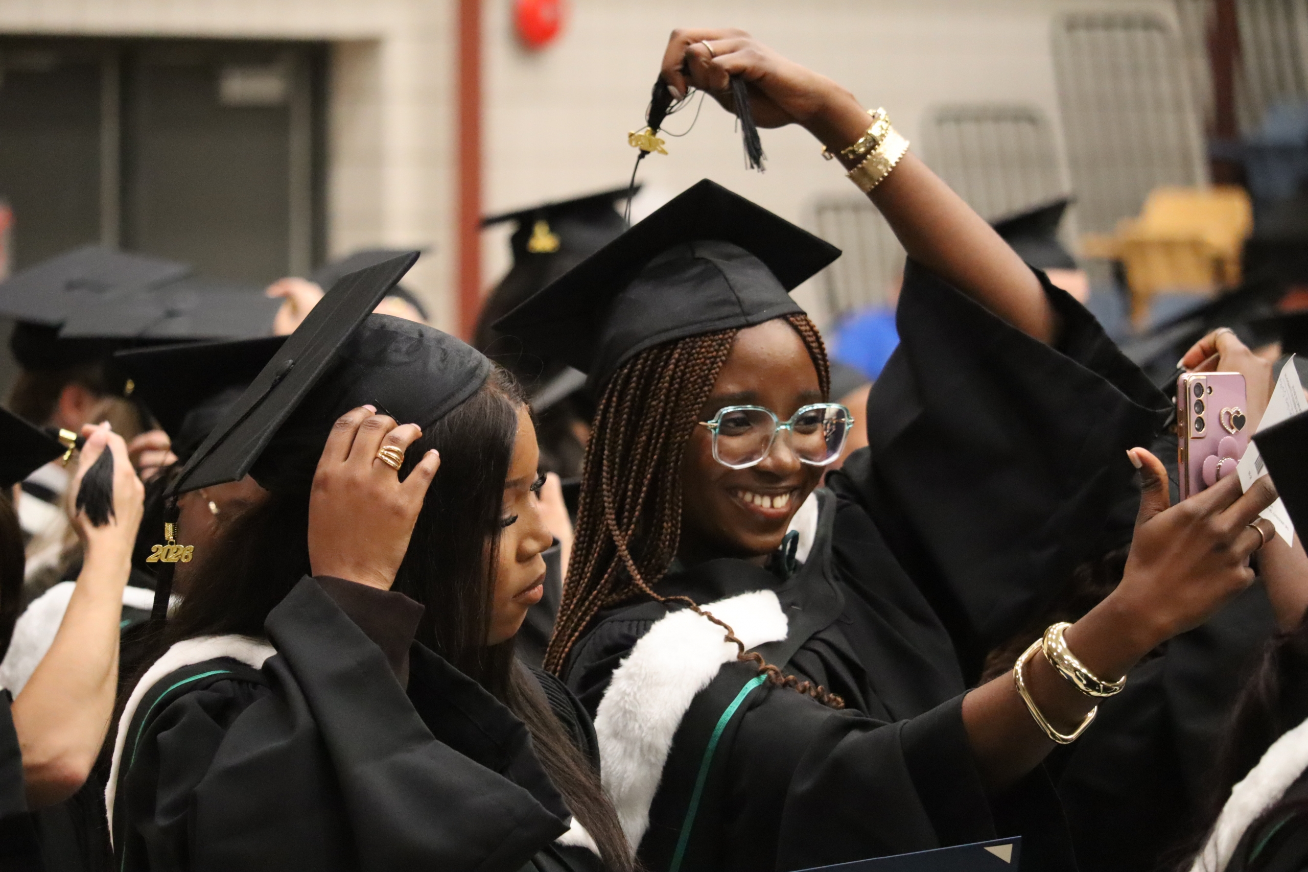 Twograduating students taking a selfie as they move their tassels at convocation.