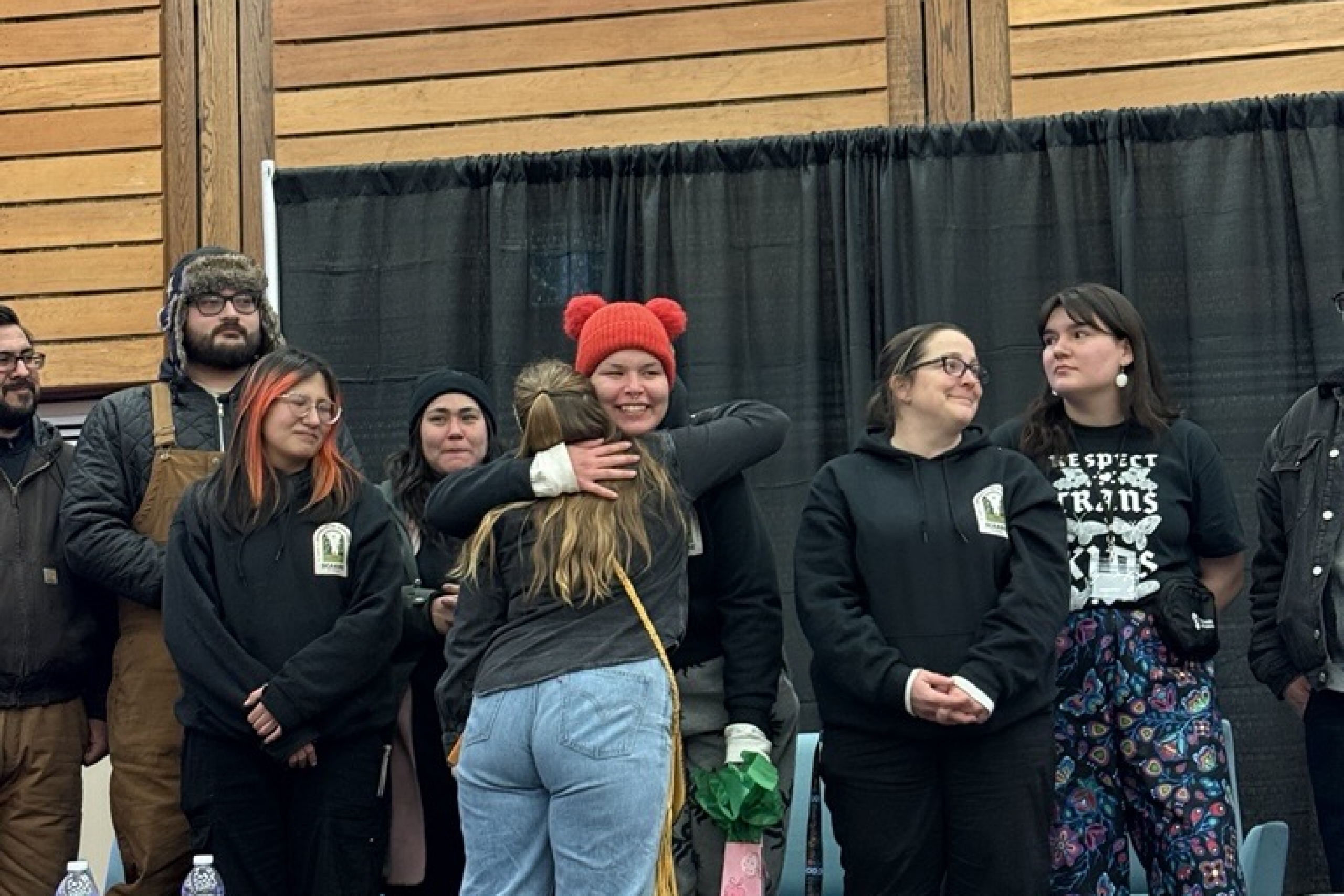 April hugs a staff member with a smile after receiving a gift.