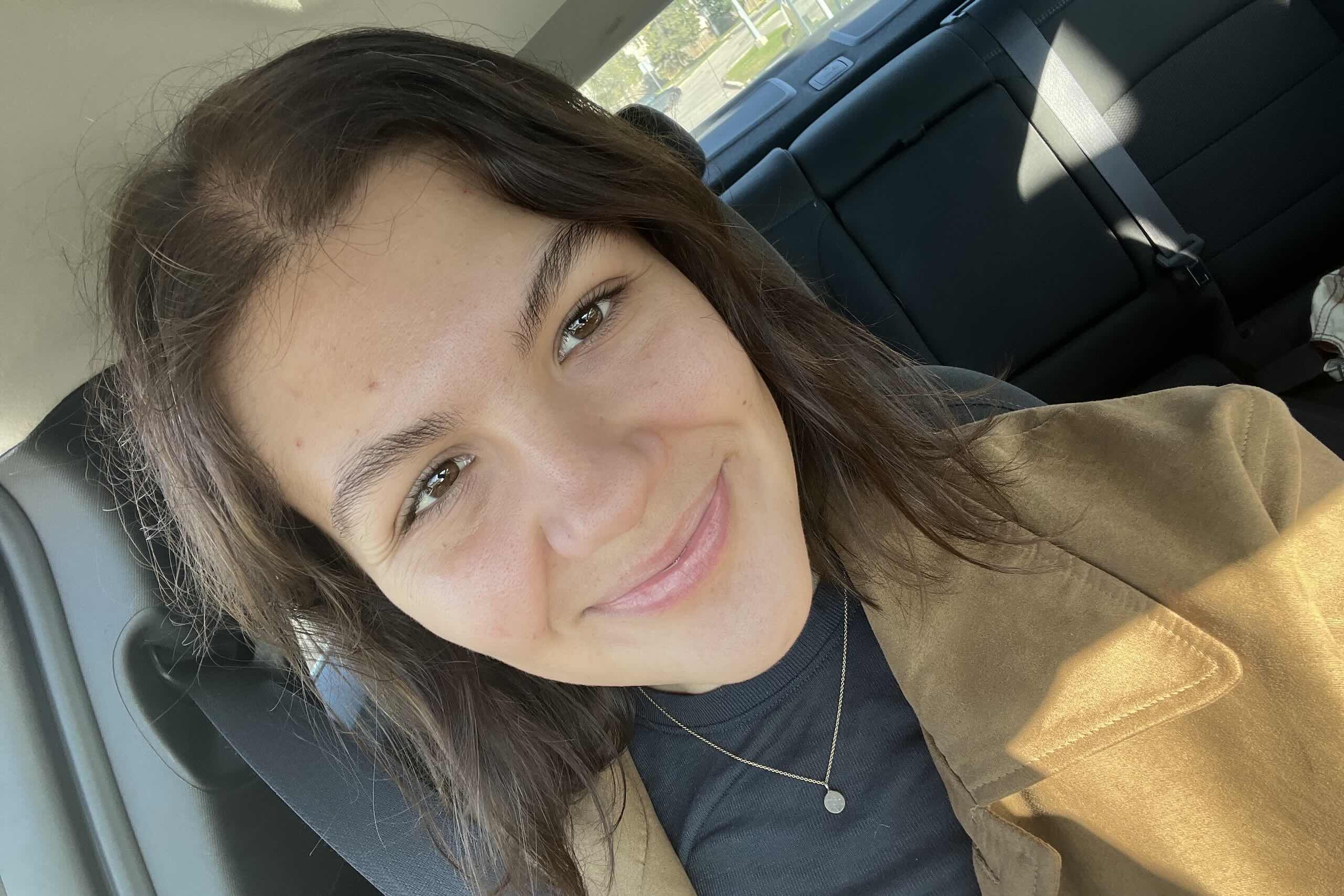 Young woman with brown hair smiling.