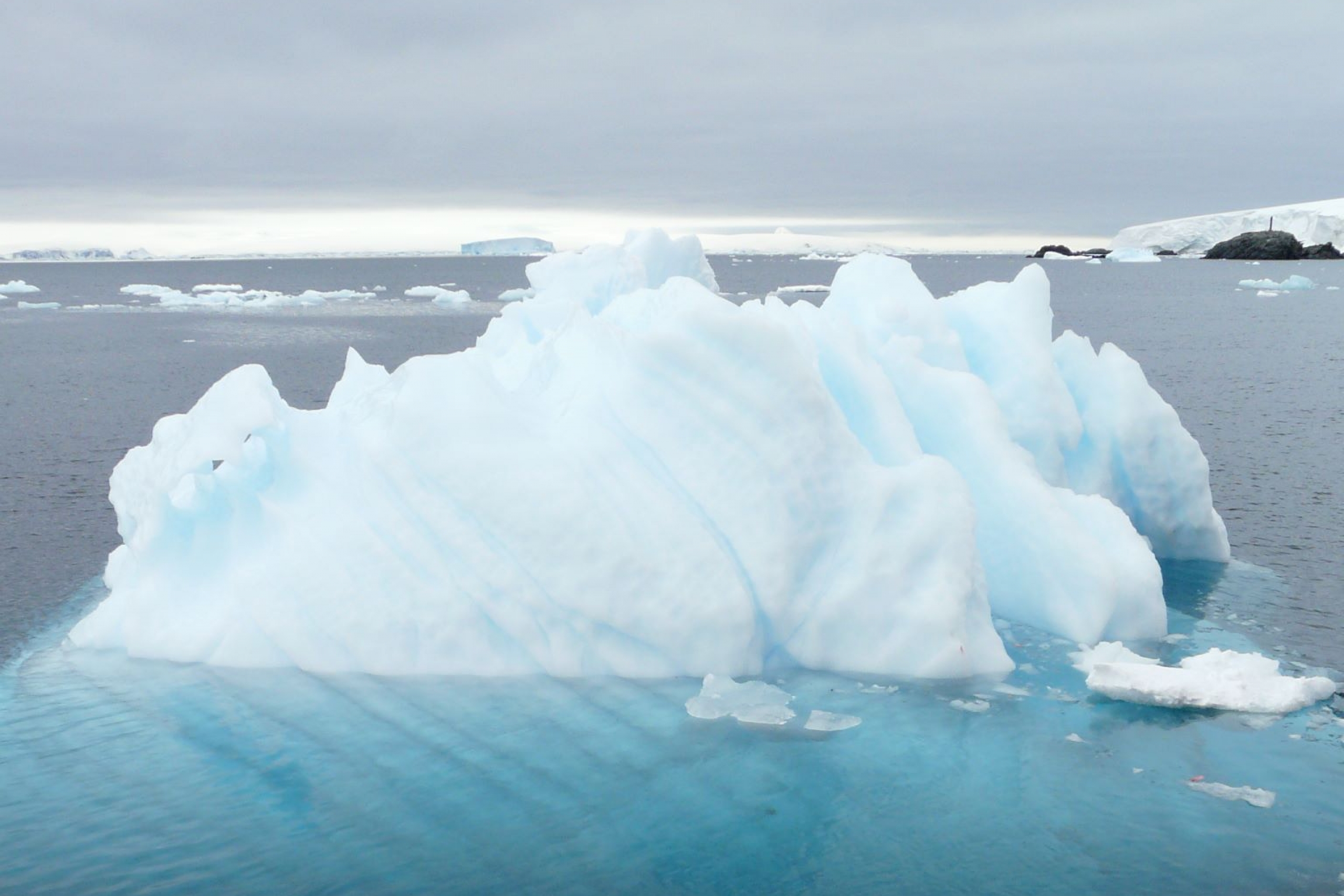 An iceberg that is submerged in water, showing briefly how deep it may truly be.