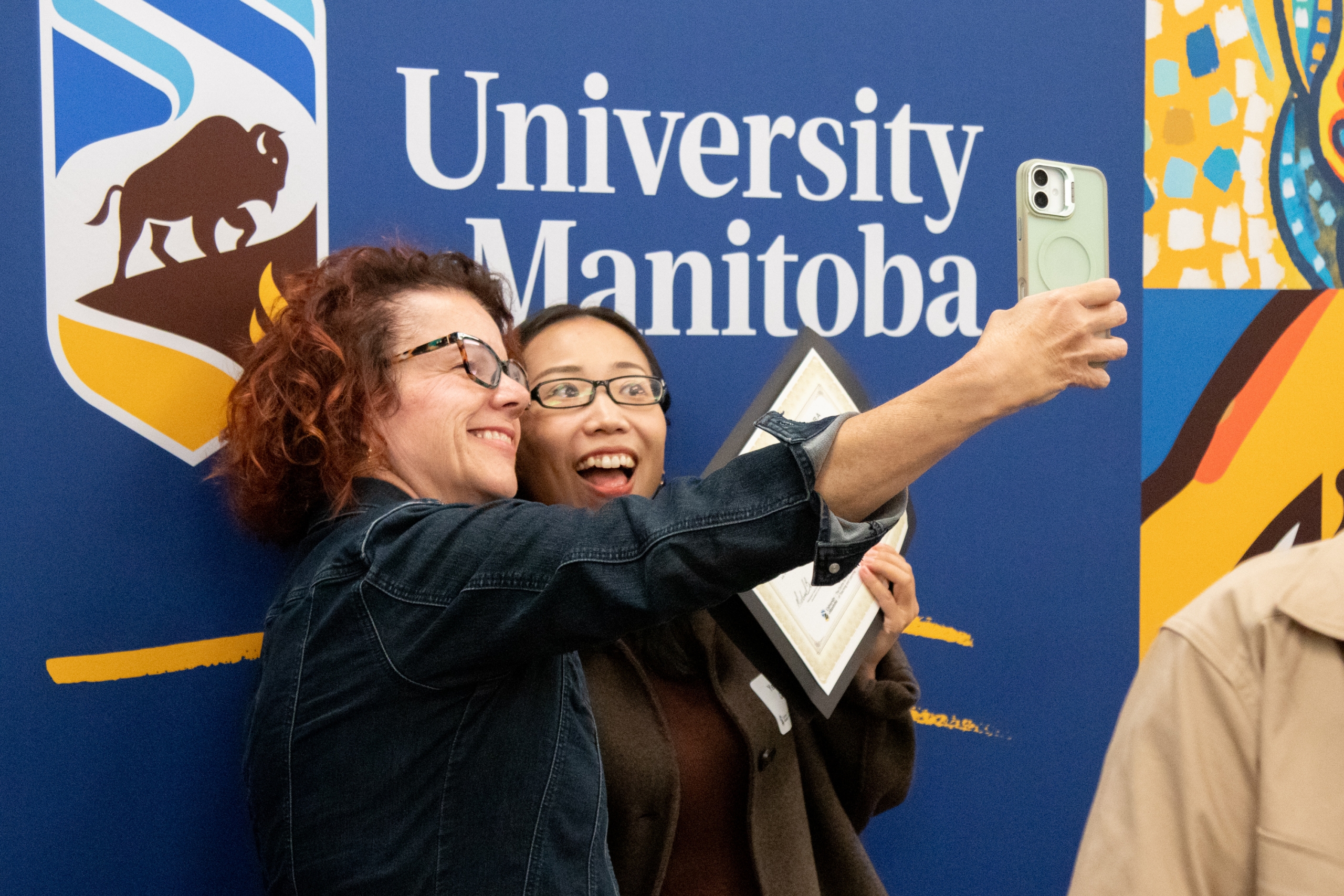 Two women are posing for a selfie to celebrate the occasion.