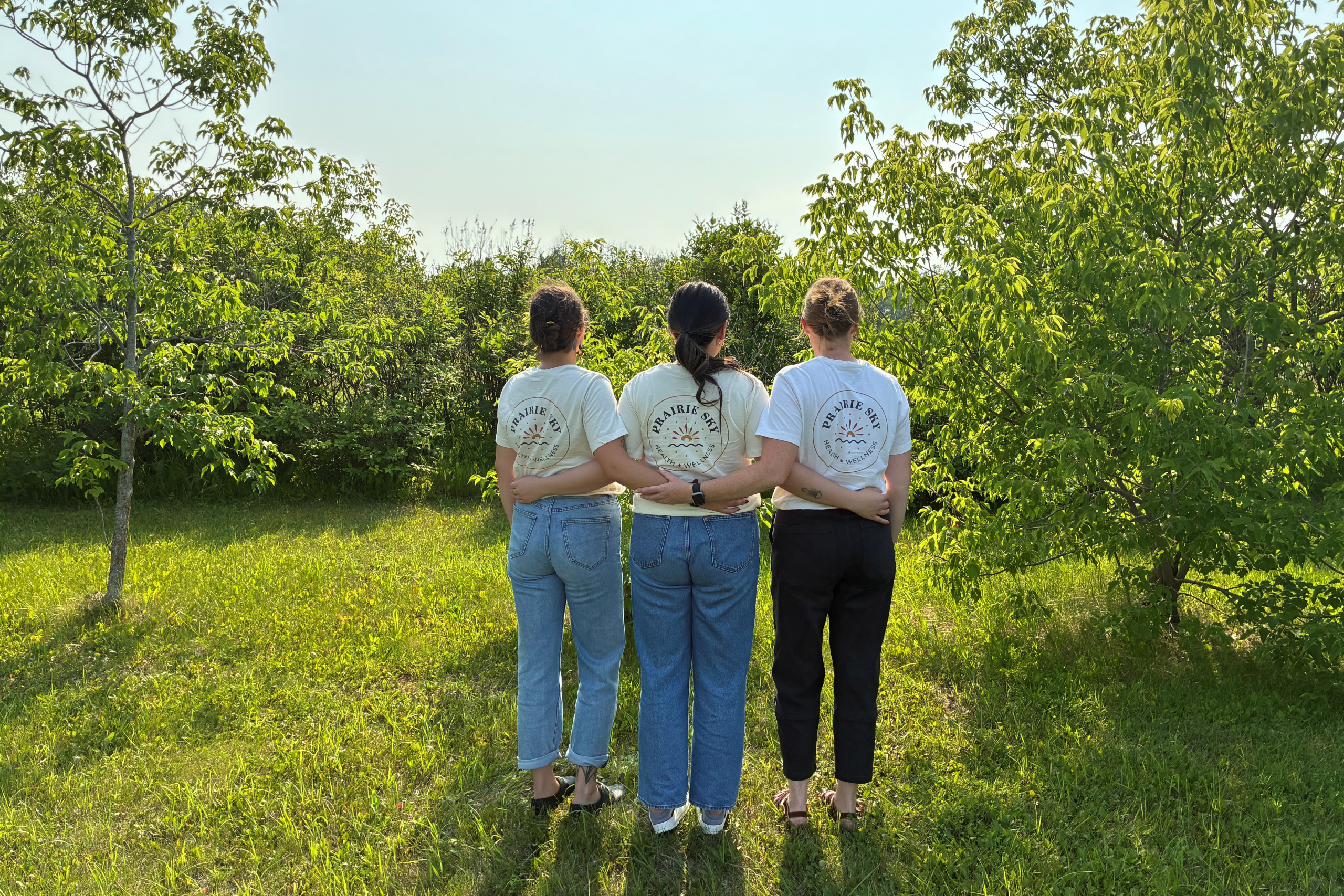 Three people outdoors with their back towards the camera.