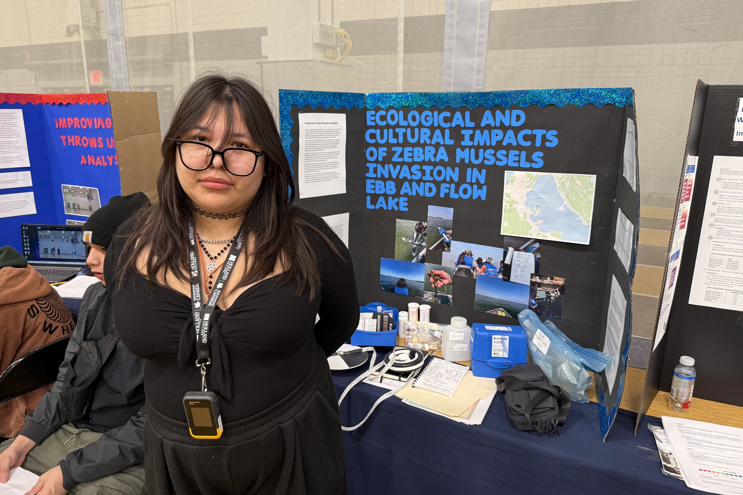 student stands in front of her poster board created for her project.