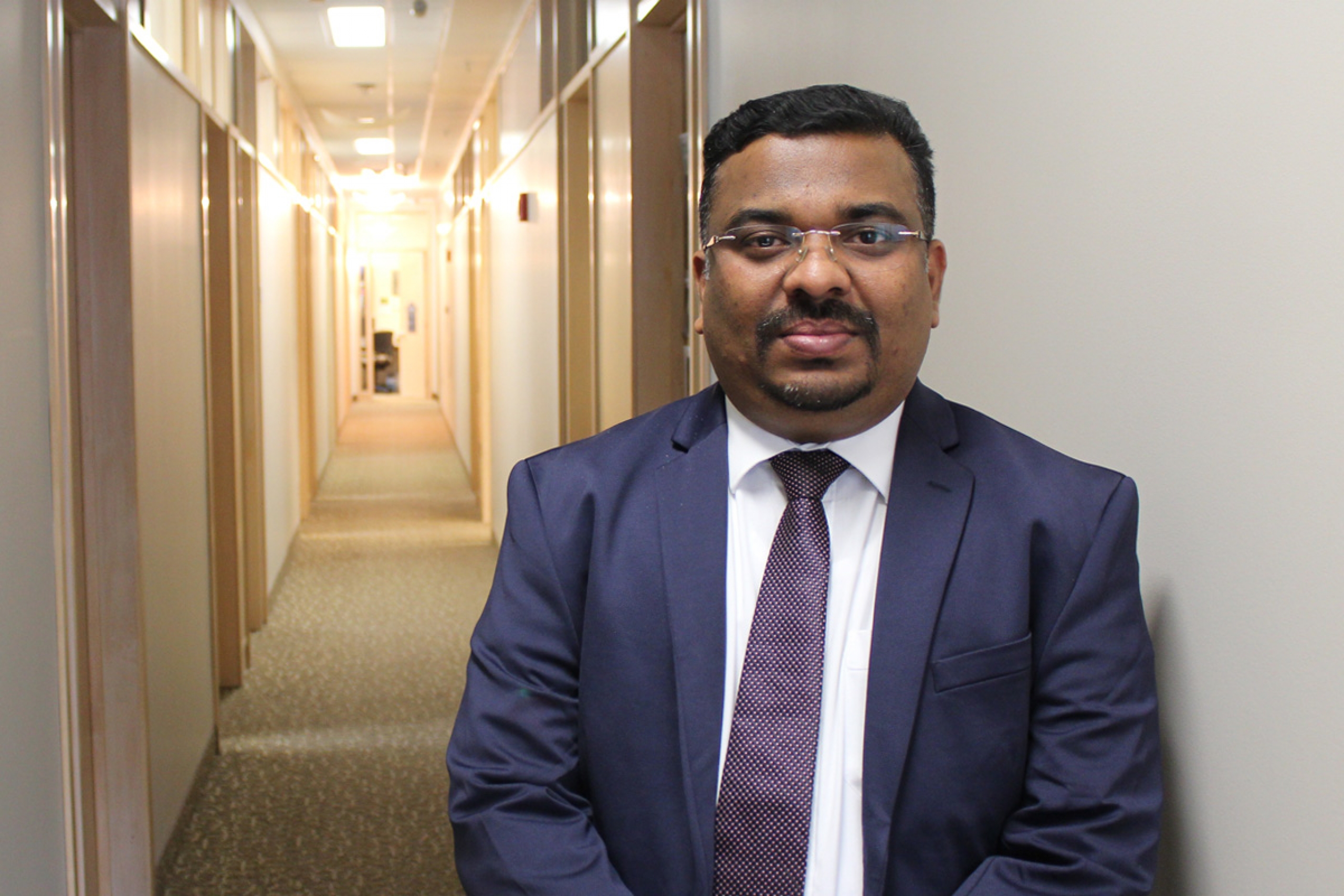 Jithan Sreedharan stands outside his office at the College of Rehabilitation Sciences.