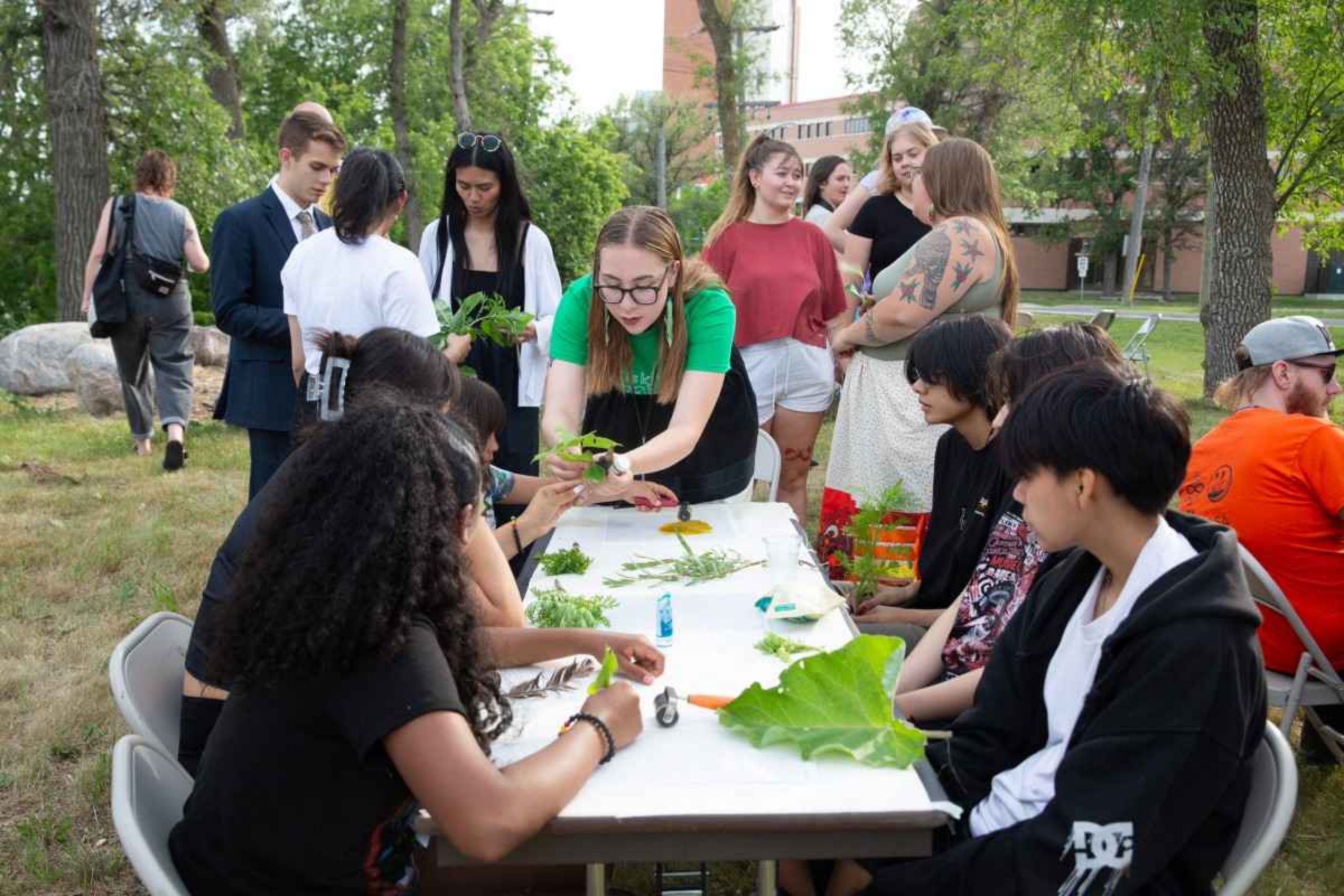 female facilitates hands-on workshop outdoors.