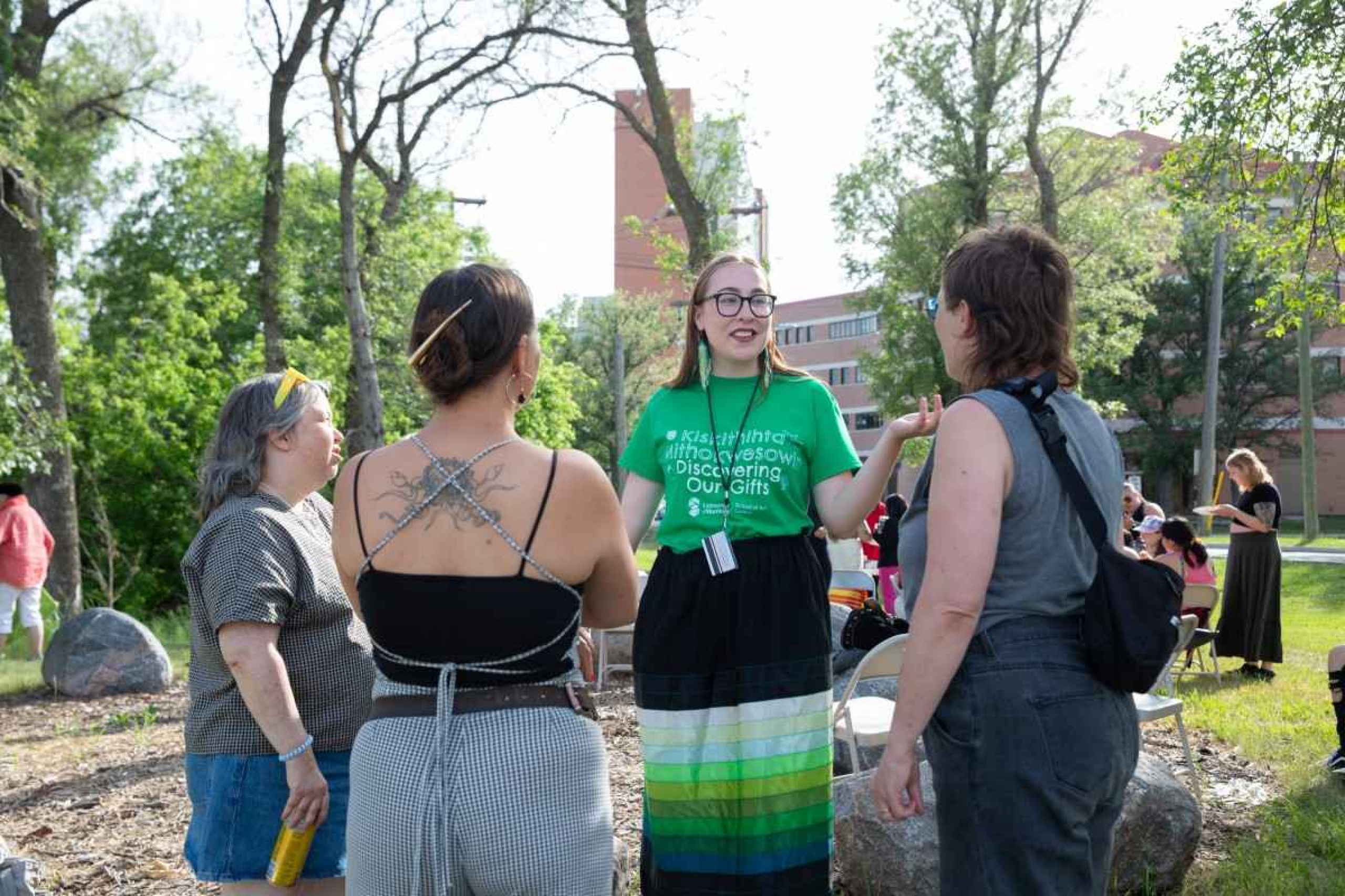 female explaining activity to peers outdoors.