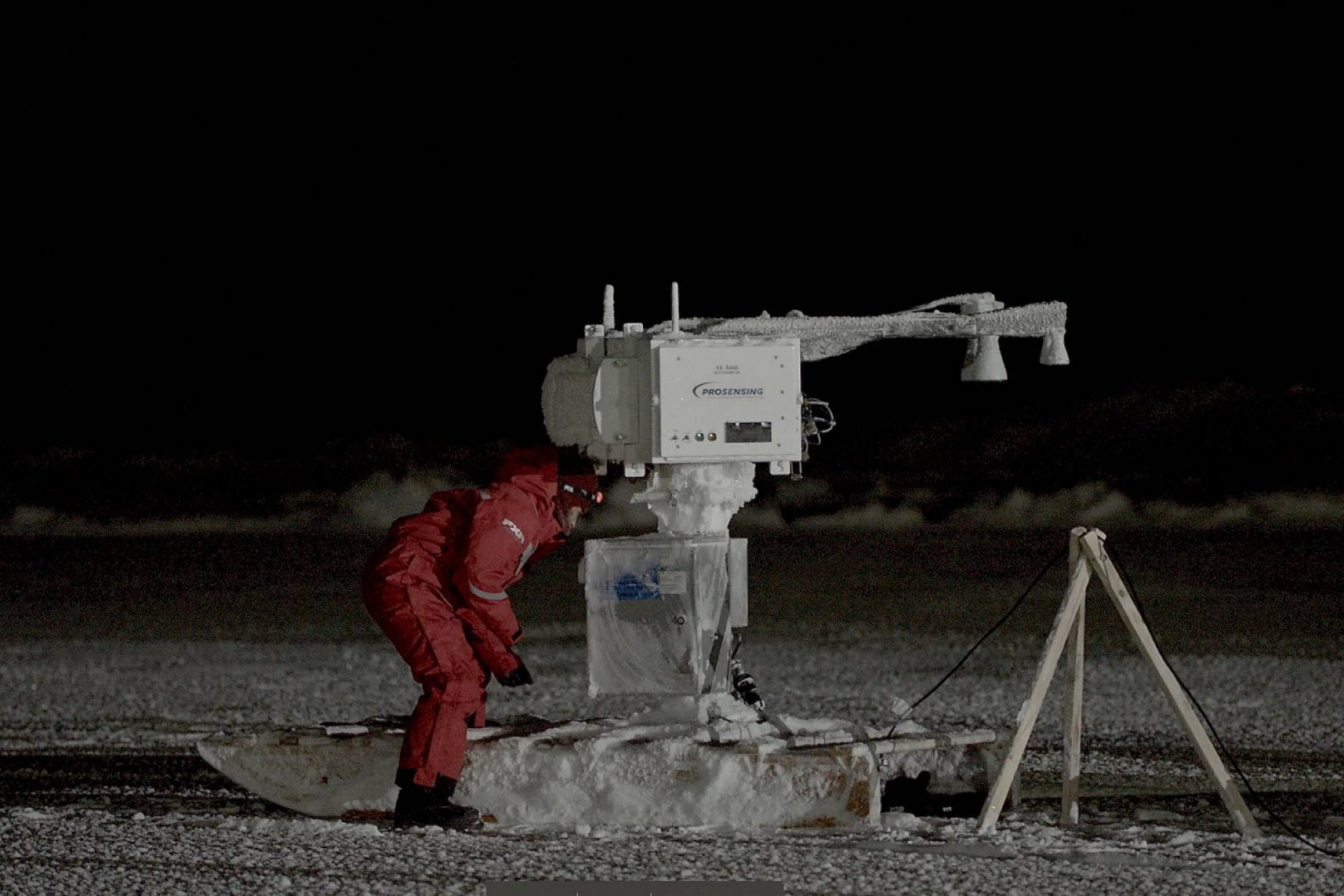 UM researcher Julienne Stroeve looking down at ice to measure thickness in Hudson Bay area.
