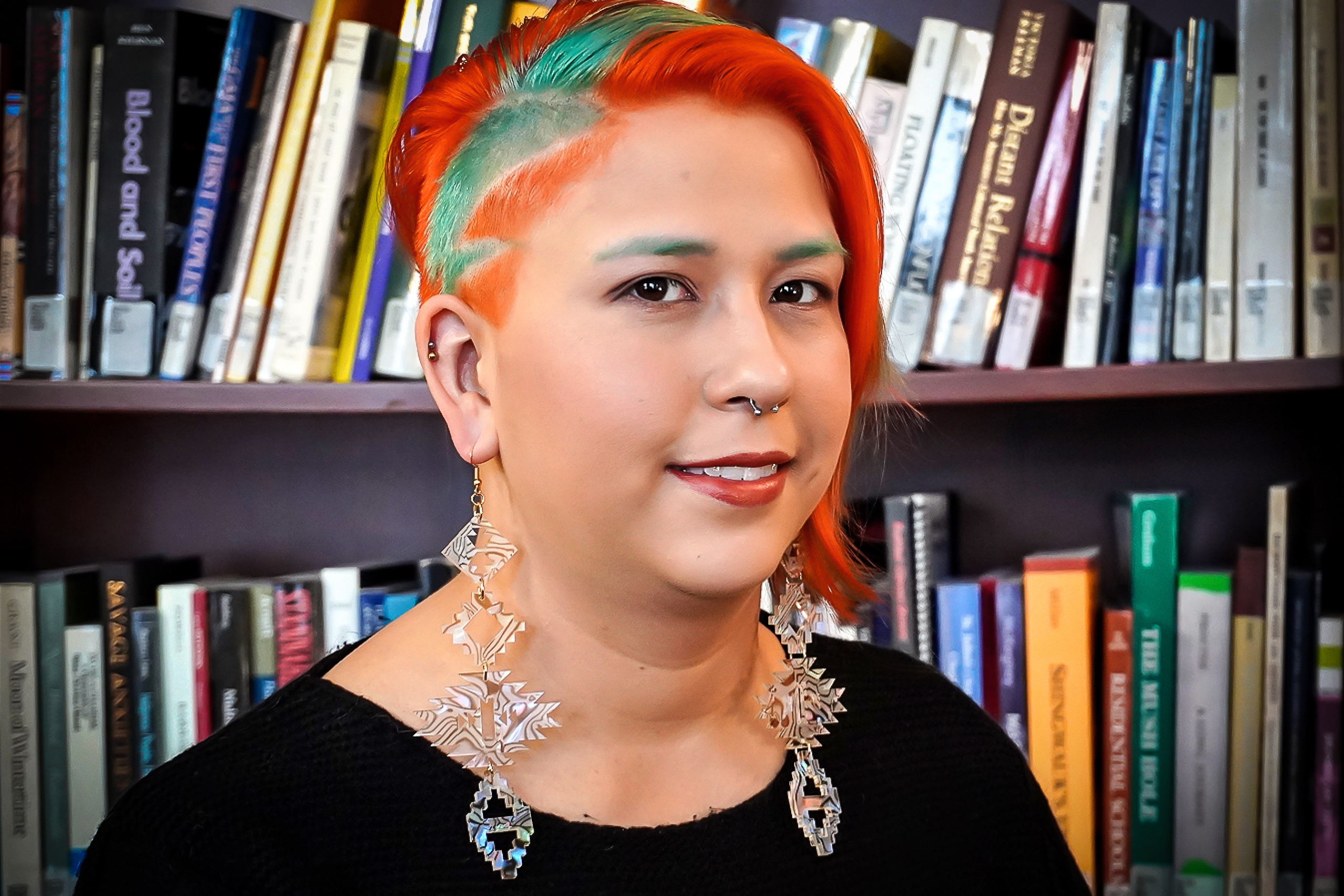 Headshot of Kaila Johnston, NCTR, standing in front of a bookcase.