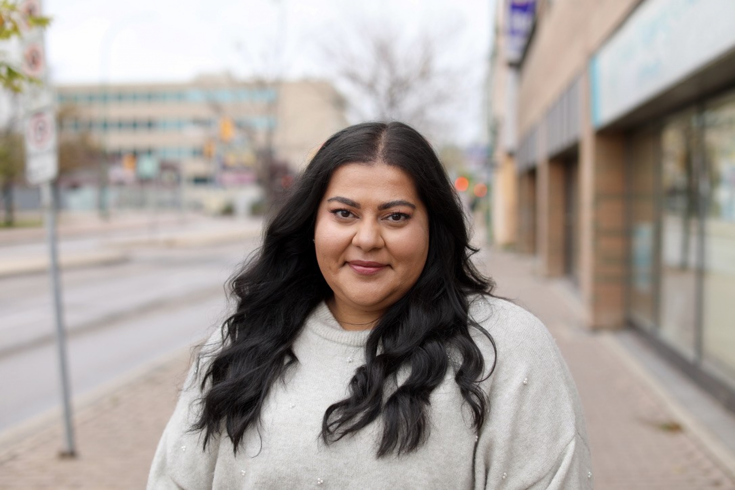A woman on a street downtown smiles
