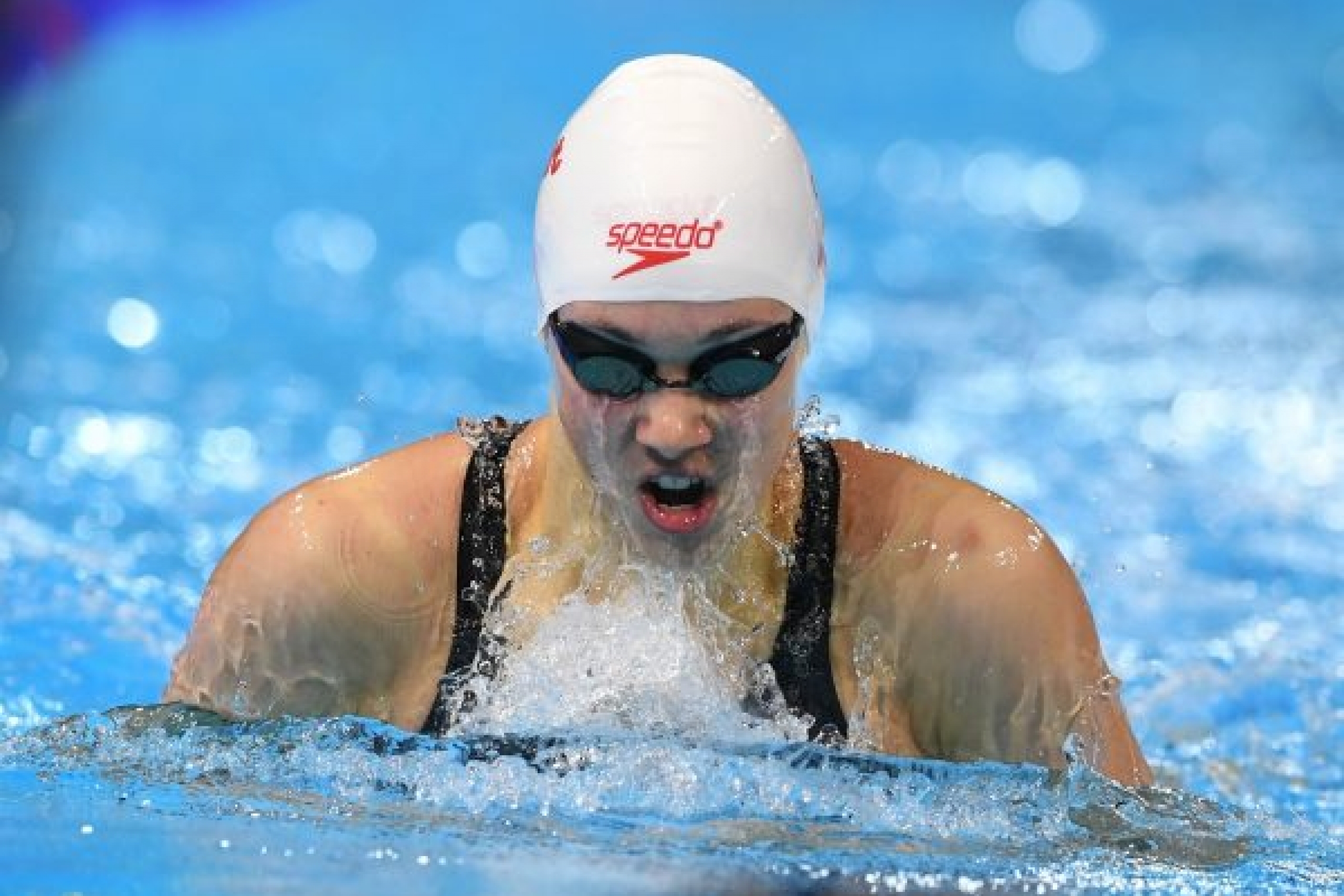 Kelsey Wog mid breaststoke at a swim meet.